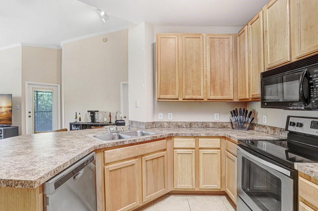 Kitchen with new stainless steel appliances 42 inch cabinets that is open to the family room