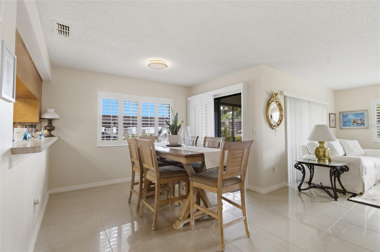 Dining Room, pass through to kitchen, living room and front patio sliders with plantation shutters