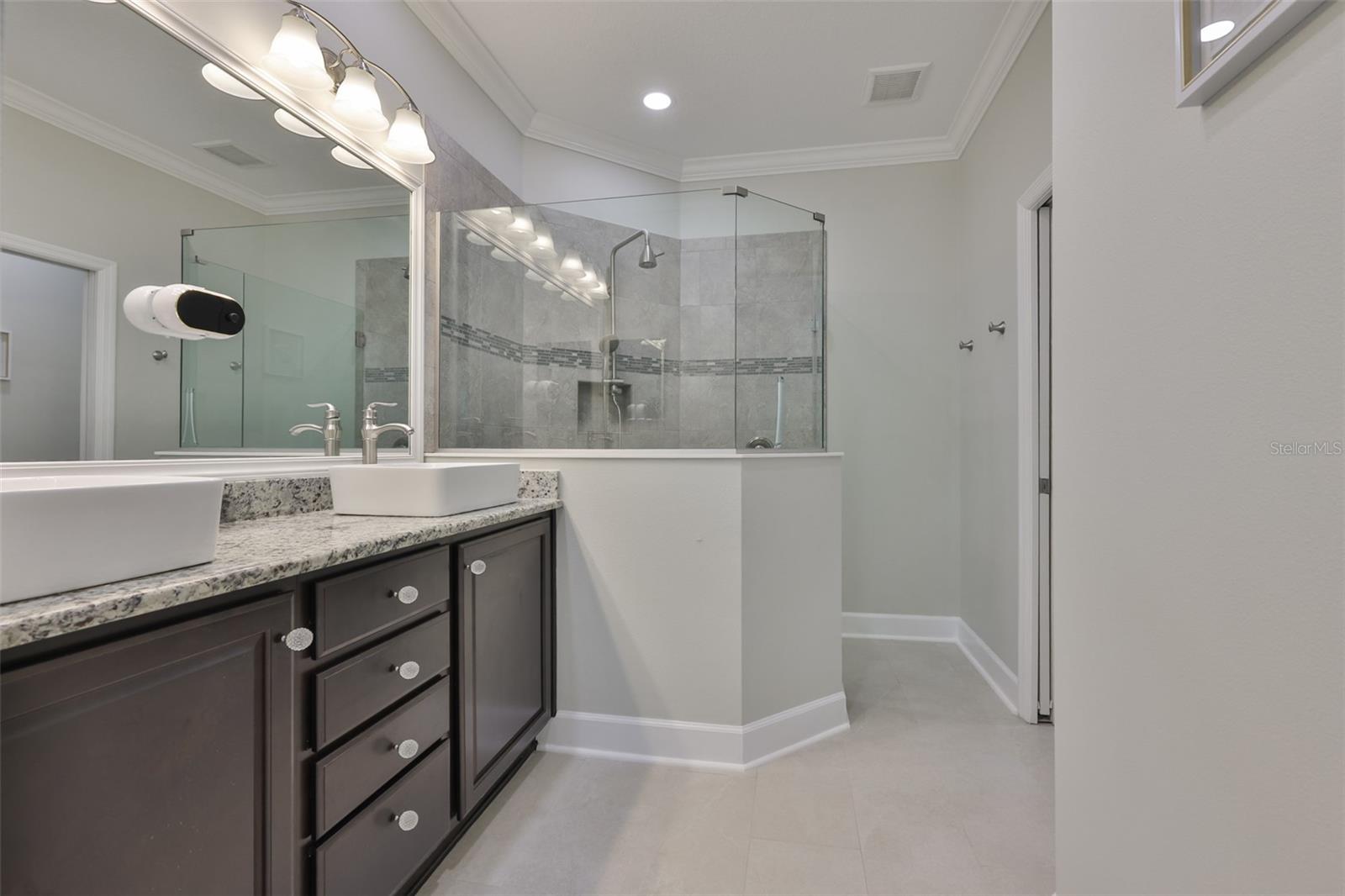 Primary bathroom is spacious with modern features and accents.