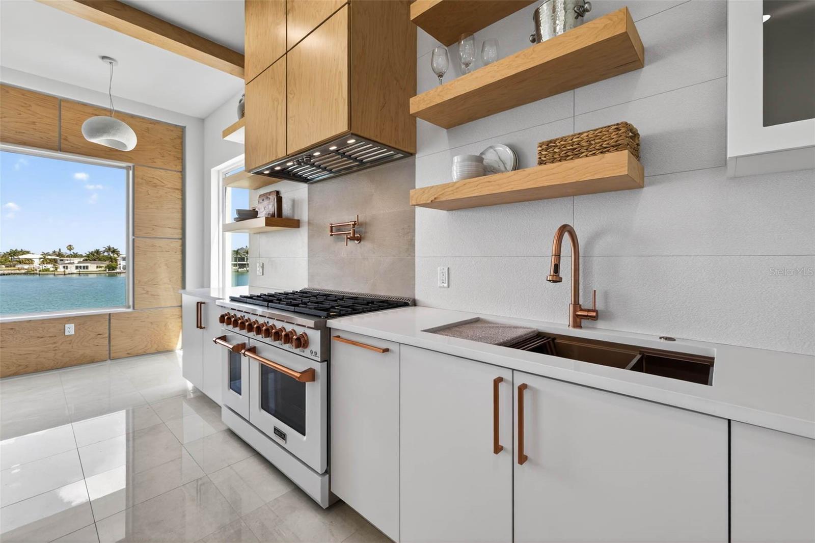 Gas range appliance with overhead vent hood.