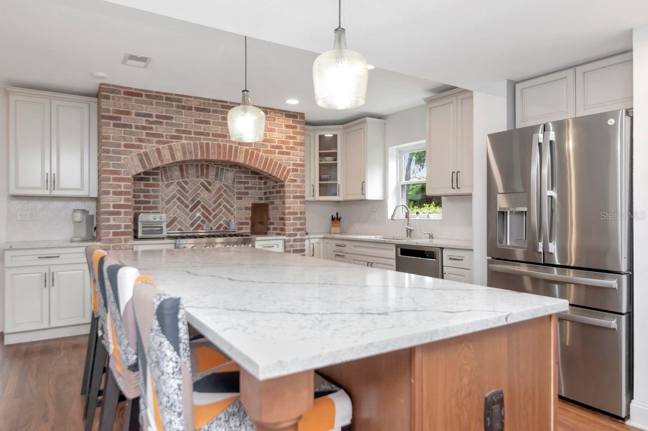Imagine Hosting Gatherings in this Chef's Kitchen with a Statement Focal Point of the Brick Alcove.