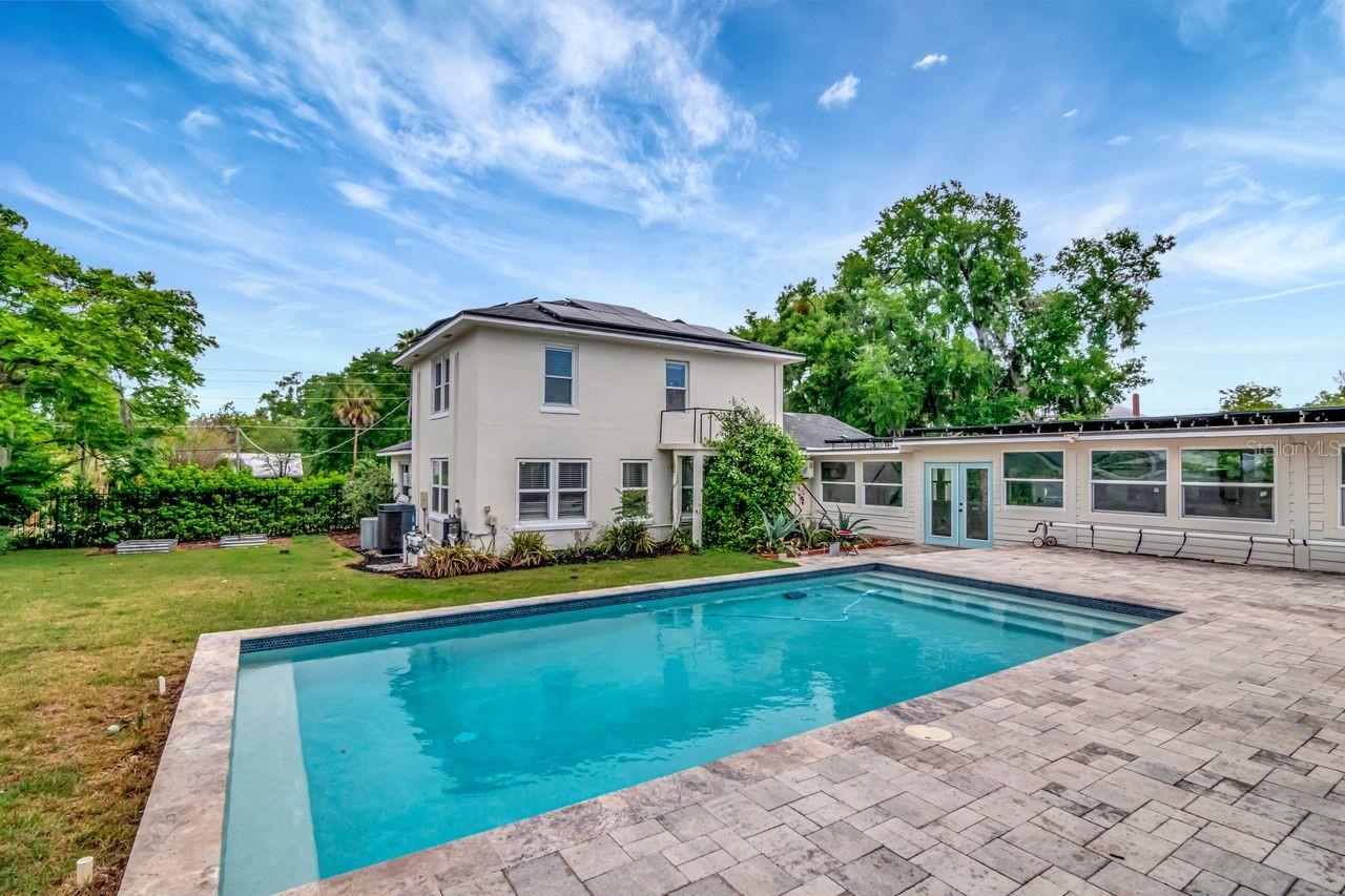 Custom Heated Salt Pool with Pavered Deck and Gazebo. Entry to Breezeway. Large Backyard and View of Back of Home.