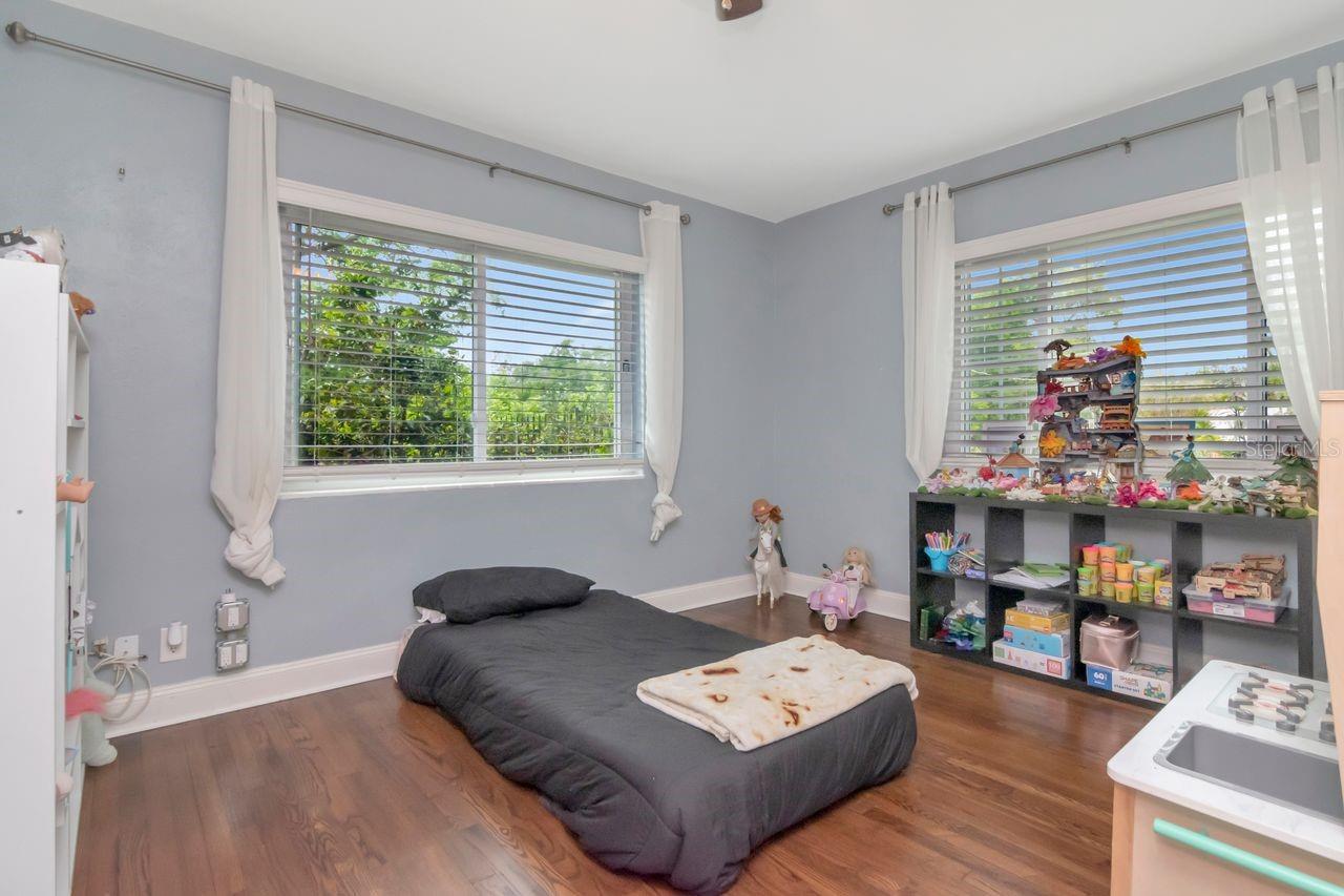 Bedroom #2 with Hardwood Floors, Ceiling Fan, and Built-In Closet.