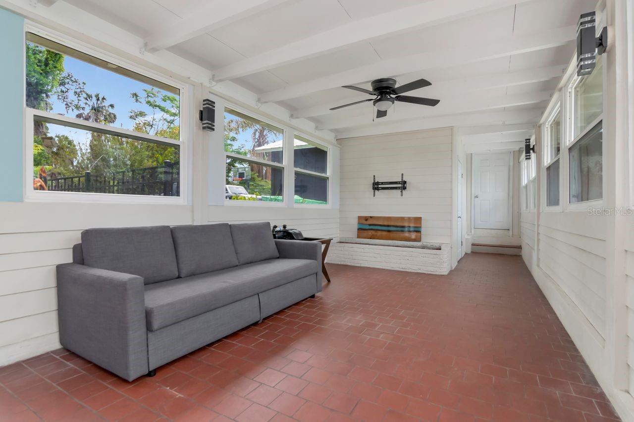 Custom Built Breezeway with dual ceiling fans and windows along both sides for natural light and a space that brings the lifestyle!