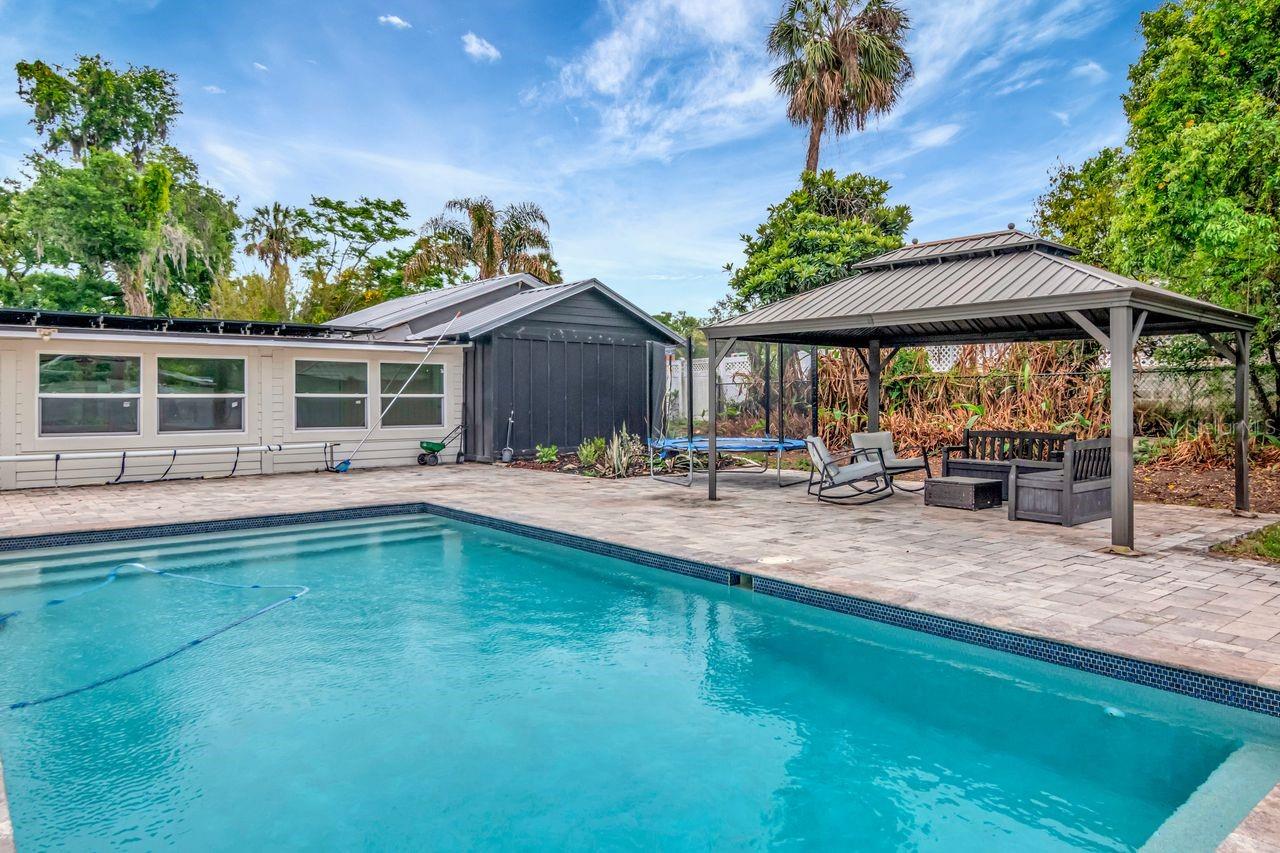 Custom Heated Salt Pool with Pavered Deck and Gazebo. Entry to Breezeway. Large Backyard and View of Breezeway and Garage/Workshop.