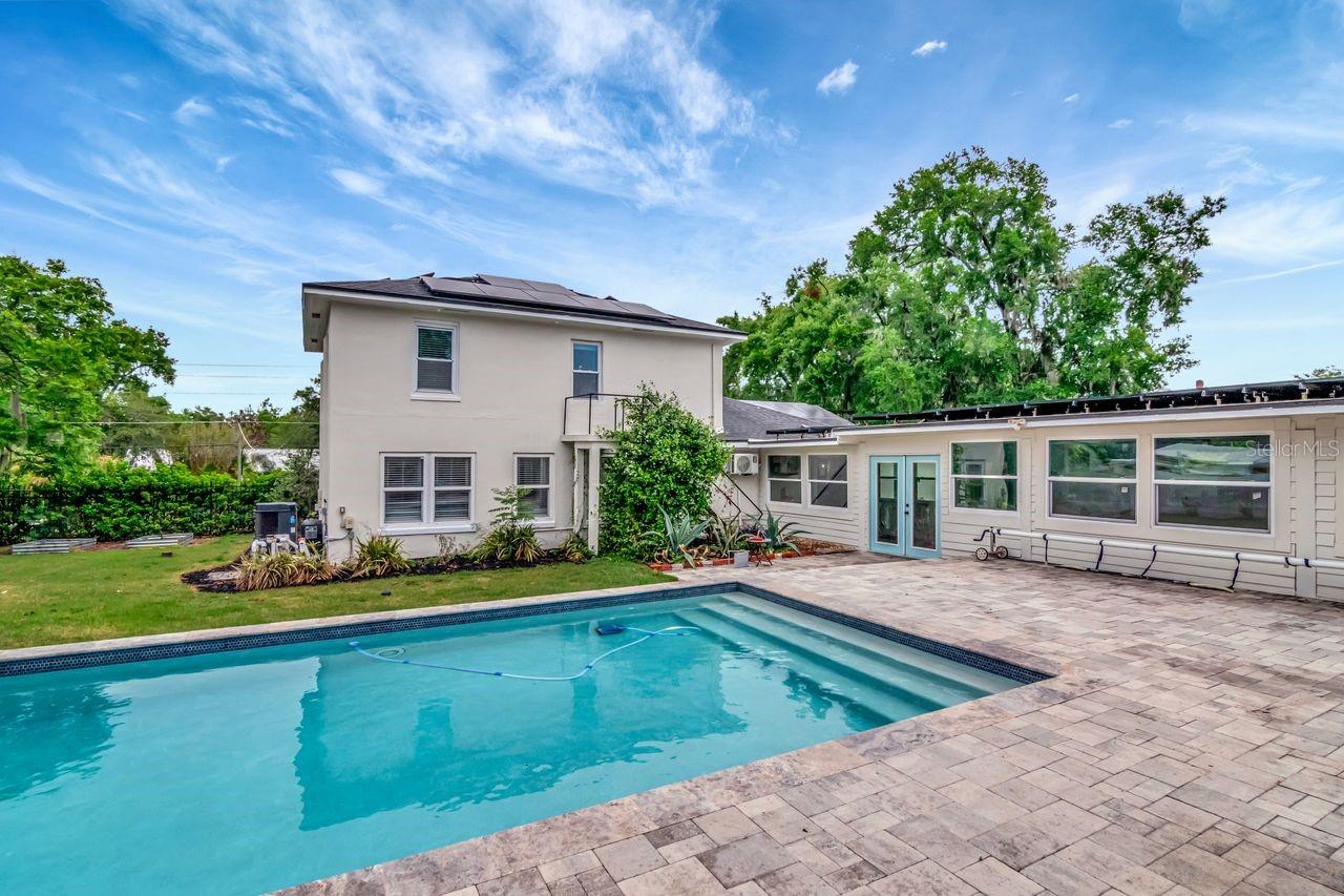 Custom Heated Salt Pool with Pavered Deck and Gazebo. Entry to Breezeway. Large Backyard and View of Back of Home.