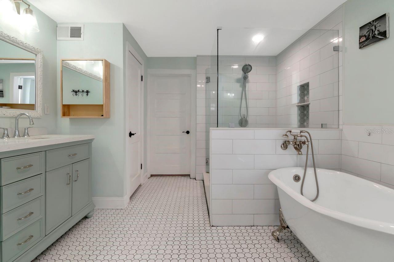 En-Suite Primary Bathroom with Dual Vanities, Upgraded Cabinets, Fixtures/Hardware, Upgraded Tile, Tile  surrounding Claw Bathtub, Large Shower Stall all tiled, Private Water Closet, Access Door to Laundry Room
