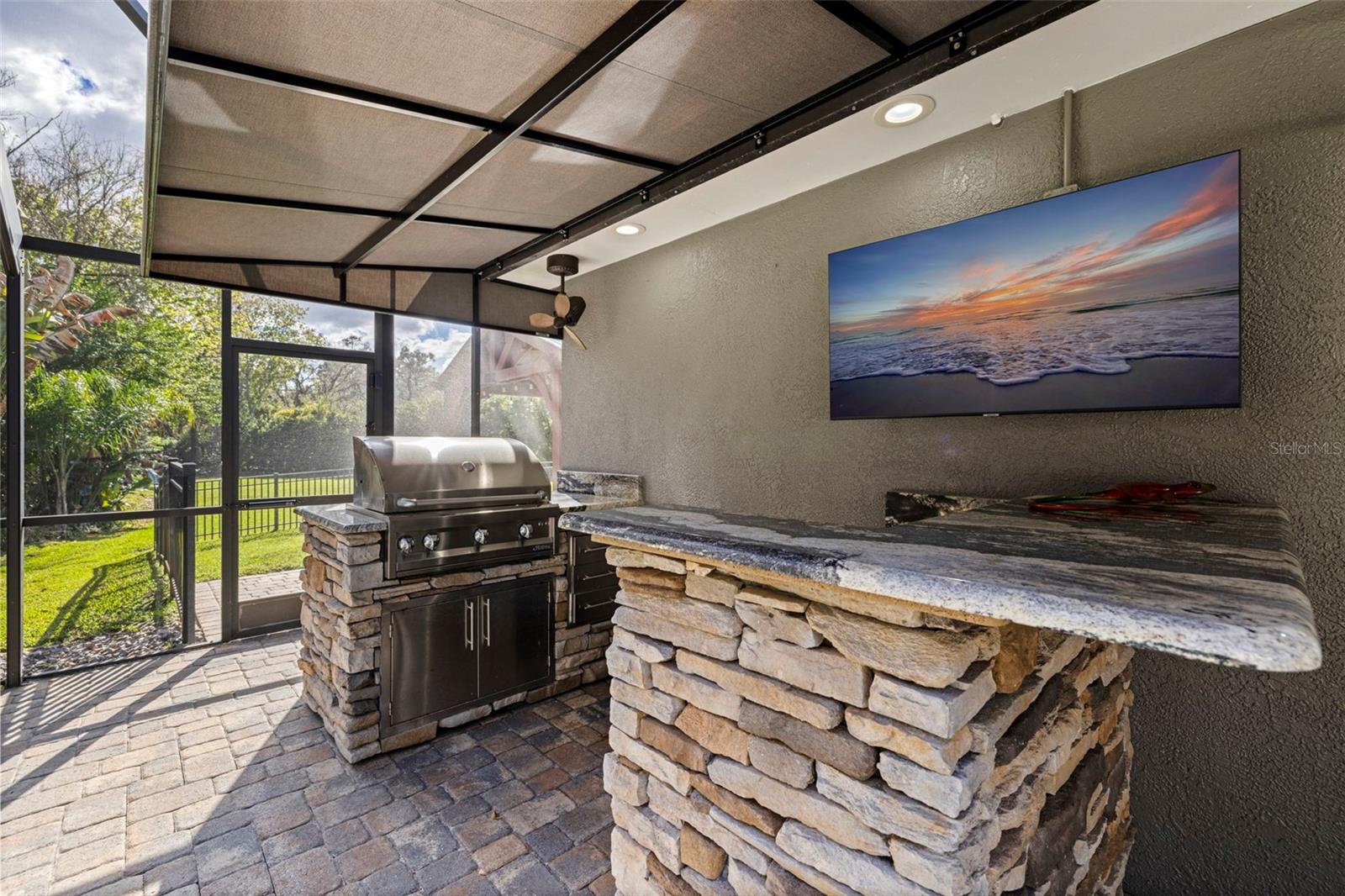 Outdoor kitchen with built-in grill and bar seating