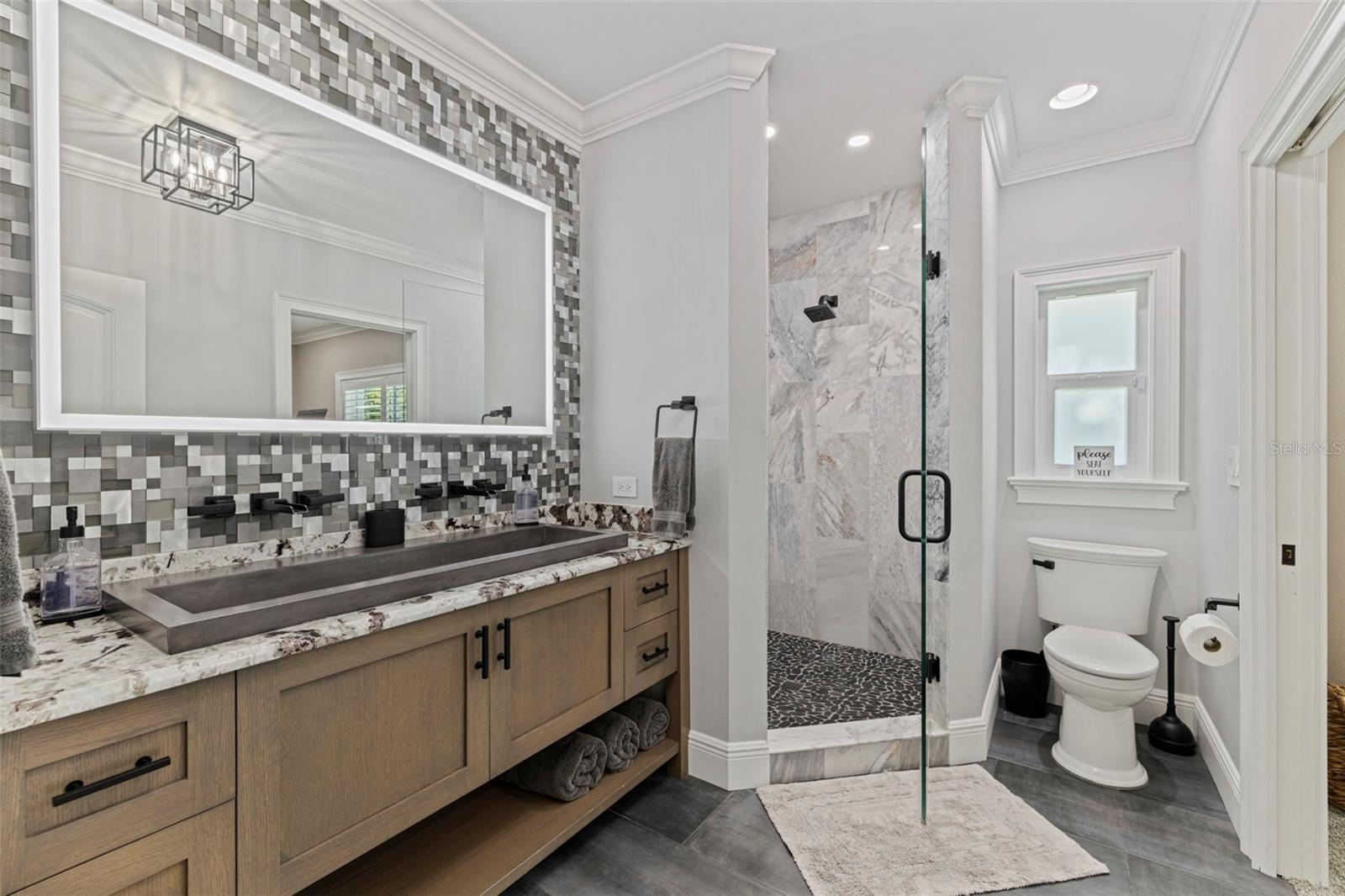 Luxury 3rd bathroom with dual sinks, detailed tile work, and spa-like feel