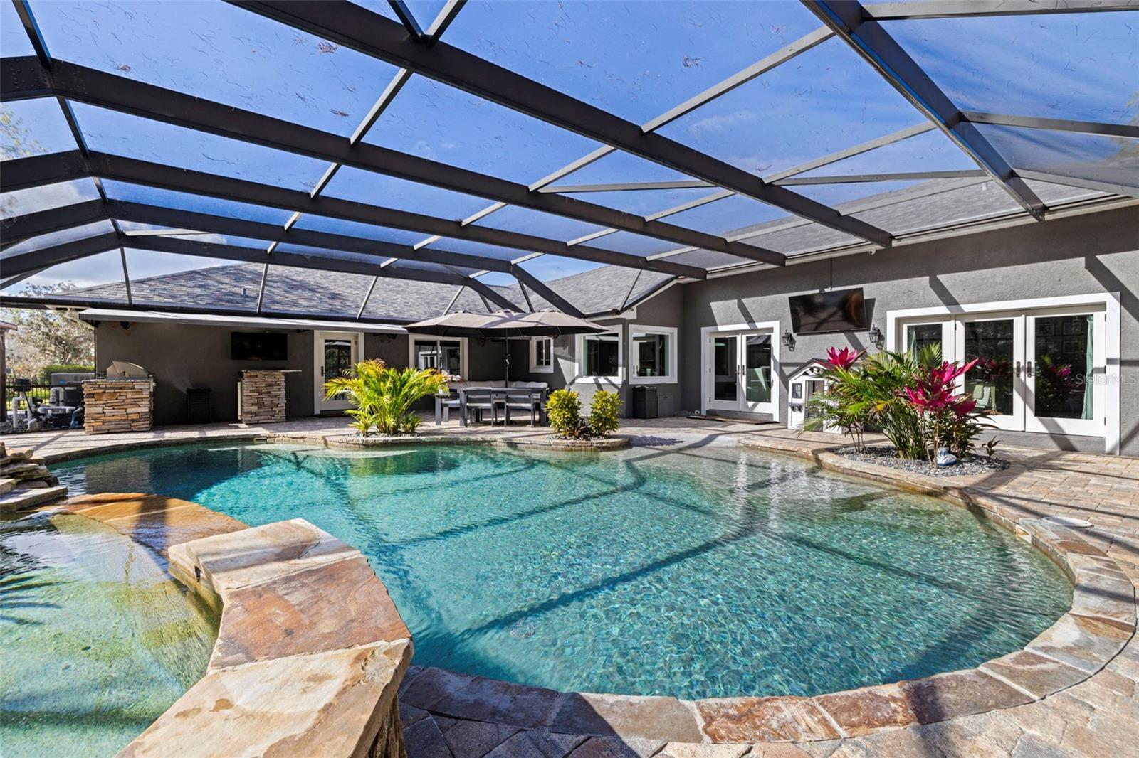 Screen-enclosed pool area with covered lanai, perfect for year-round outdoor living and entertaining