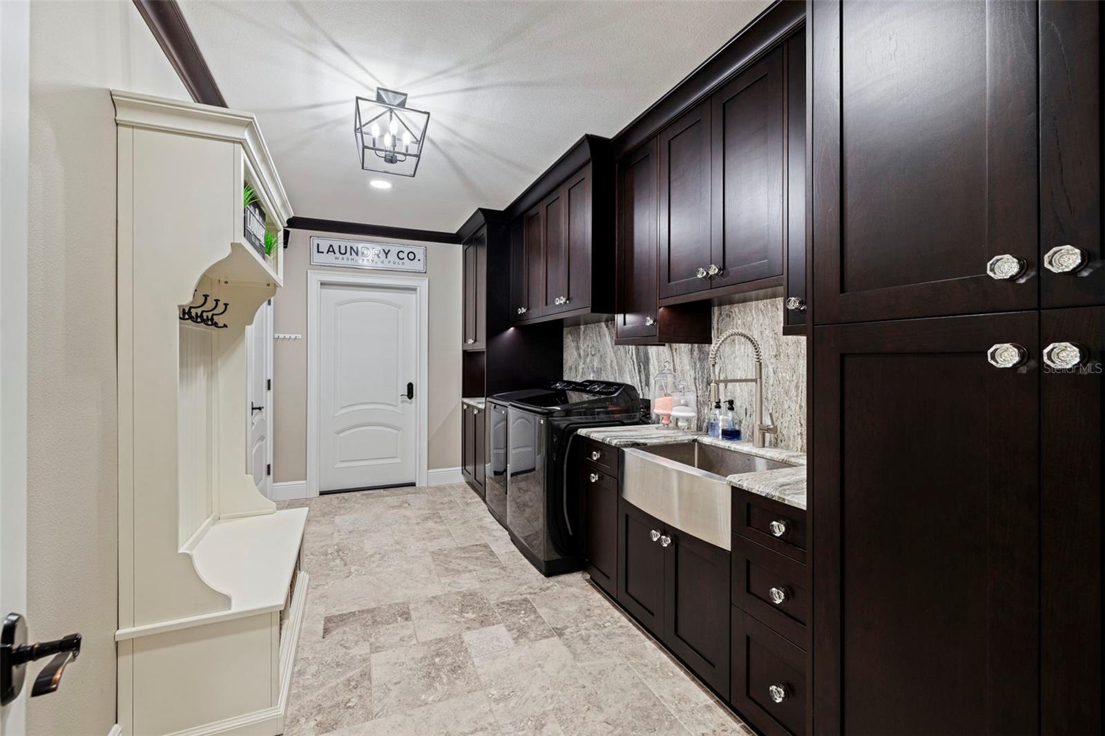 Functional laundry room with storage and pull down drying rack.