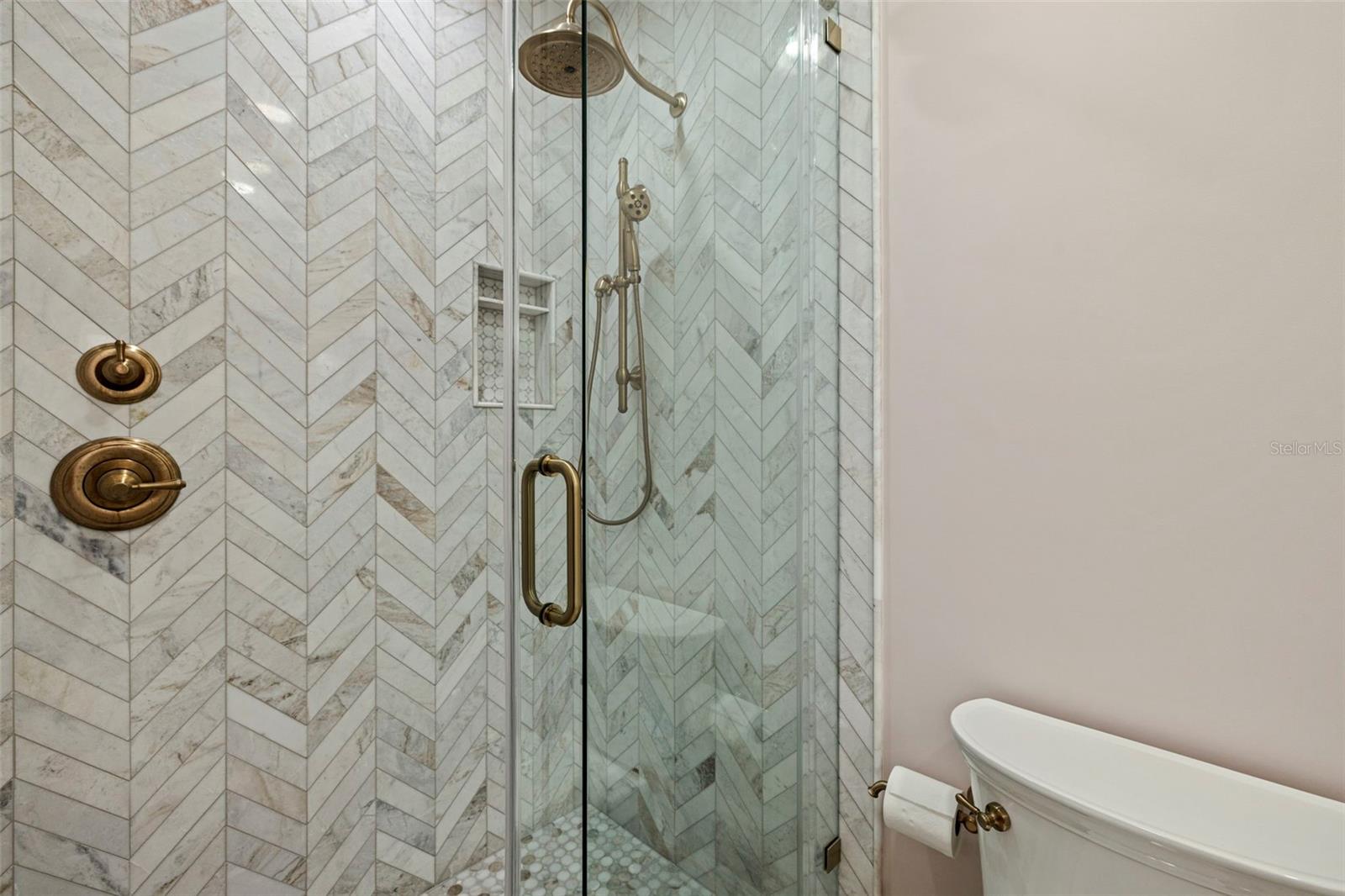 Walk-in shower with custom tile work and glass enclosure