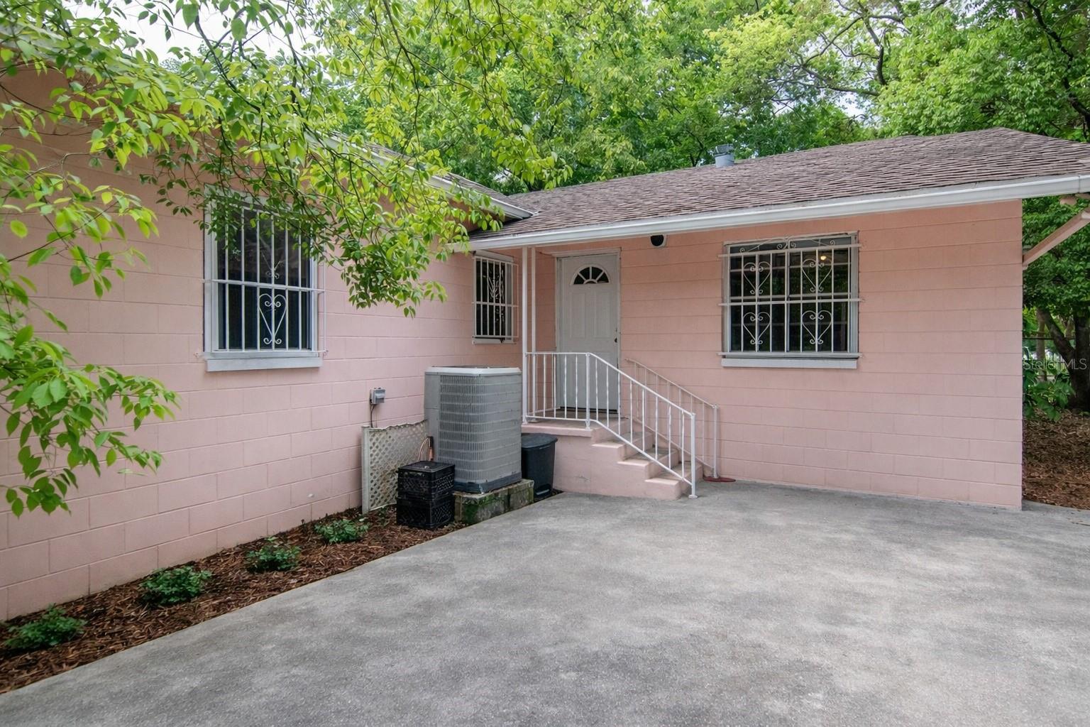 Side exterior view of the home; landscaping has been digitally enhanced for presentation and marketing purposes.