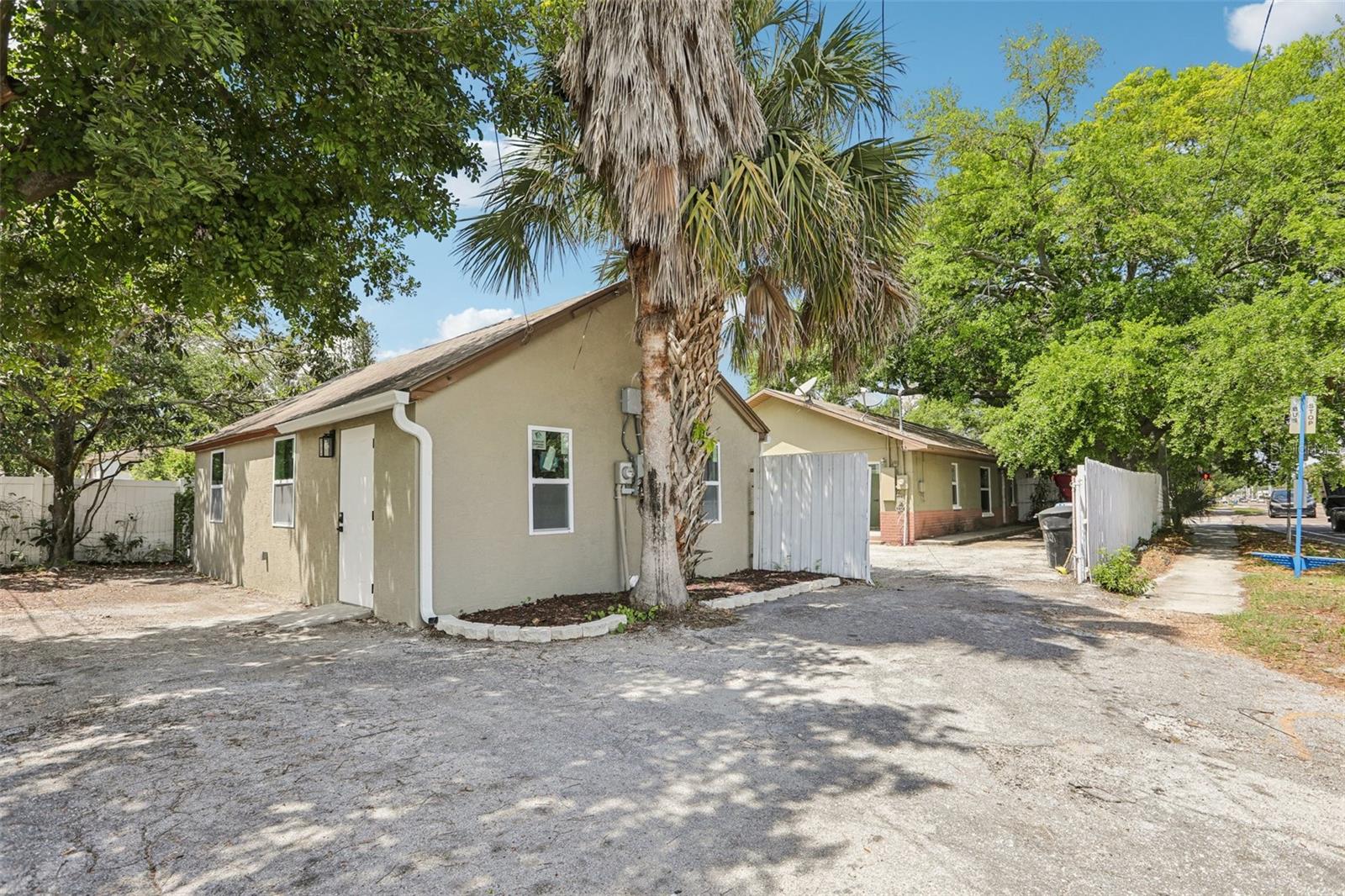 Rear corner shot of both guest house and main house with rear parking behind guest house
