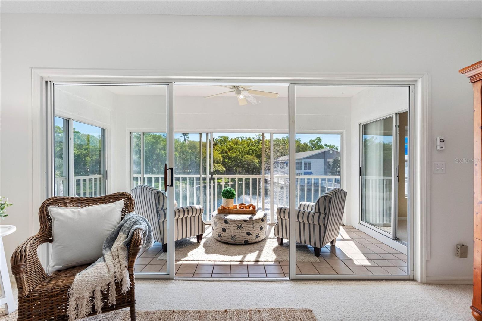... Interior shot of Lanai from Living Room Area.. The Glass Enclosed Lanai allows you to keep the Liivng Room Sliders Open..