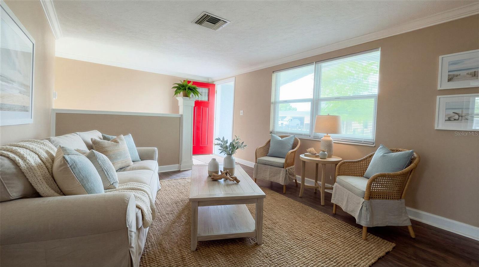 Spacious living area featuring updated laminate flooring and elegant crown molding throughout.