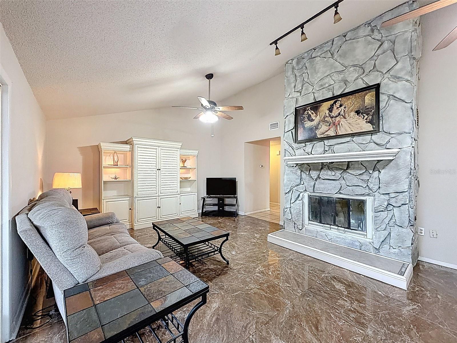 Vaulted ceilings in the living room plus wood-burning fireplace with floor to ceiling stonework.