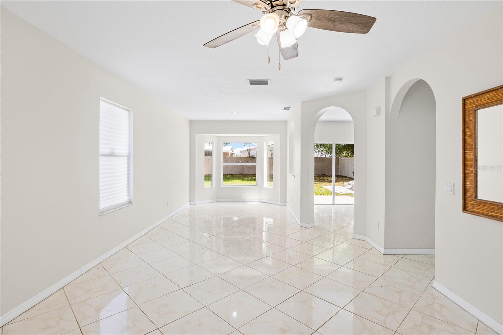 Step into a light and bright living and dining space with soaring ceilings and view of back yard.