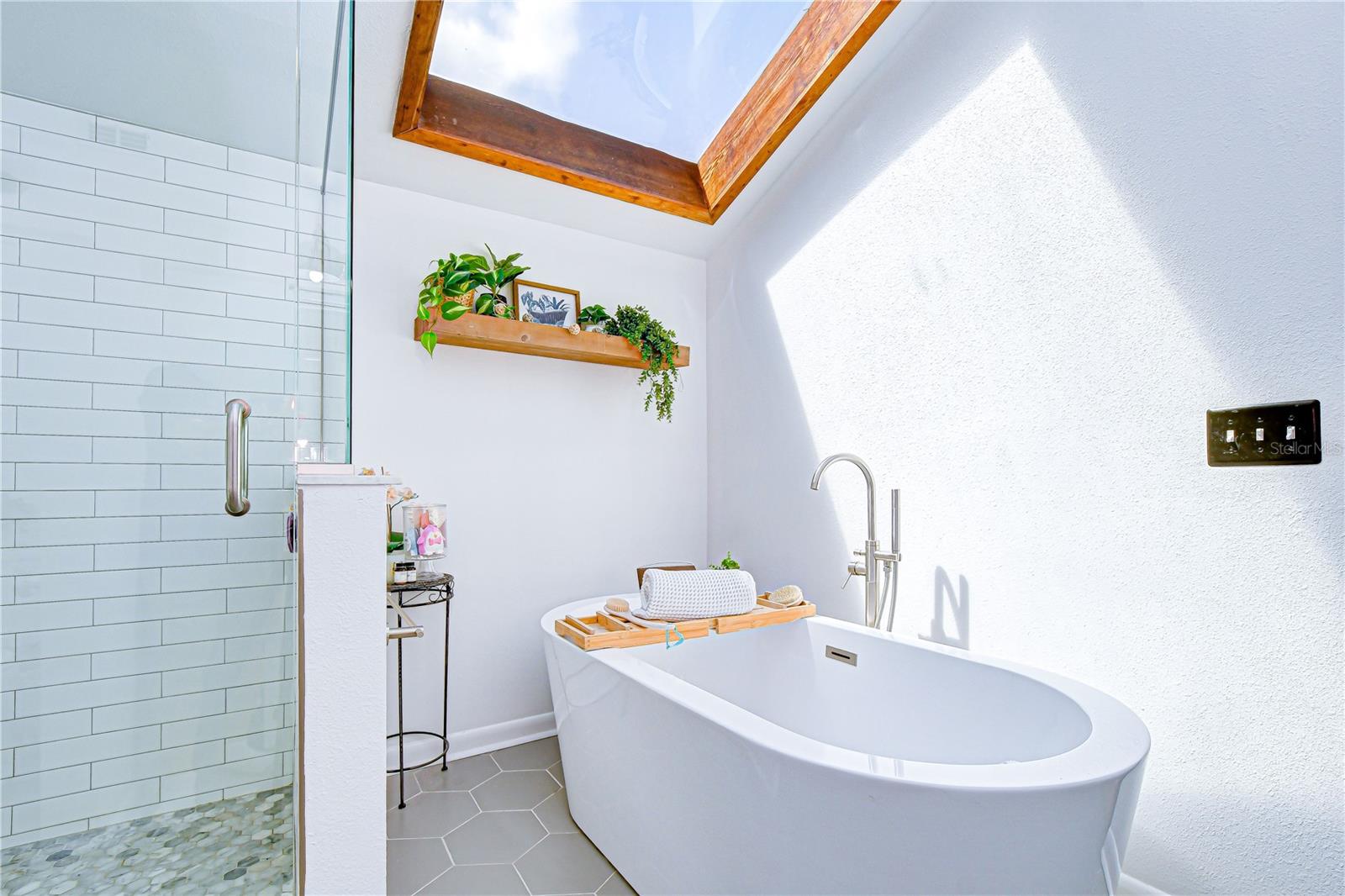 Standalone soaking tub and separate shower.
