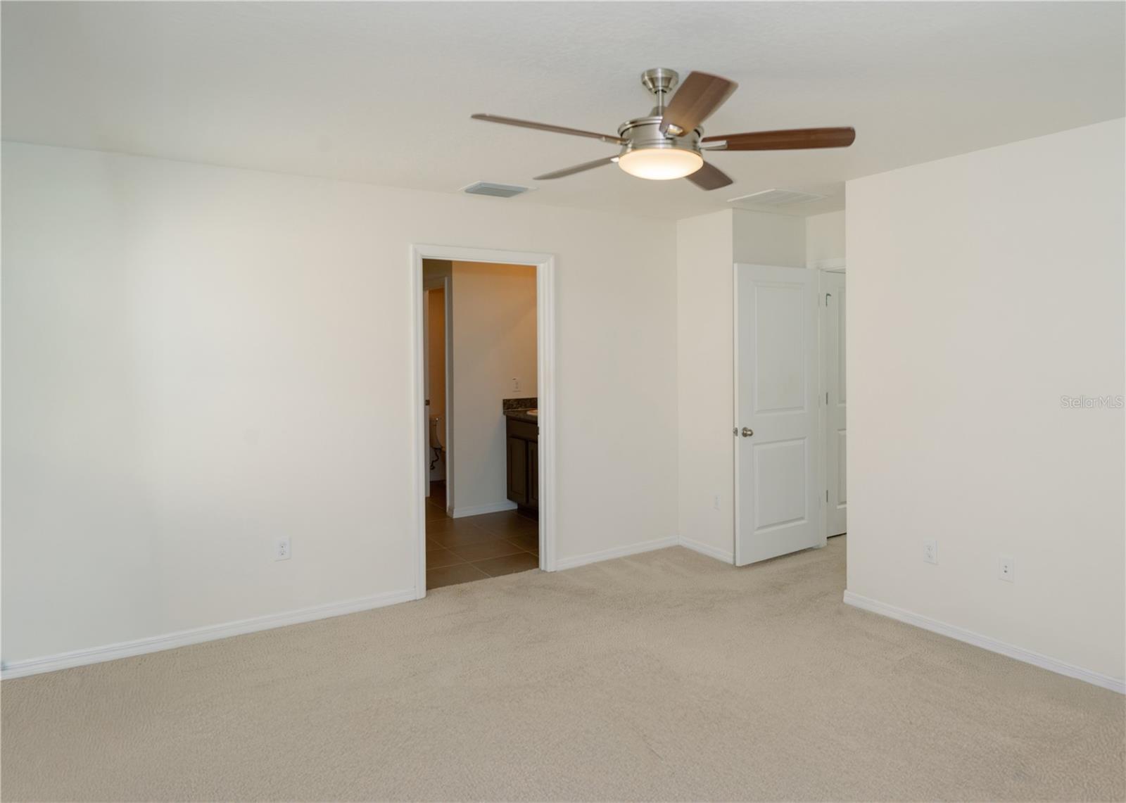 Primary bedroom looking towards the ensuite primary bathroom door