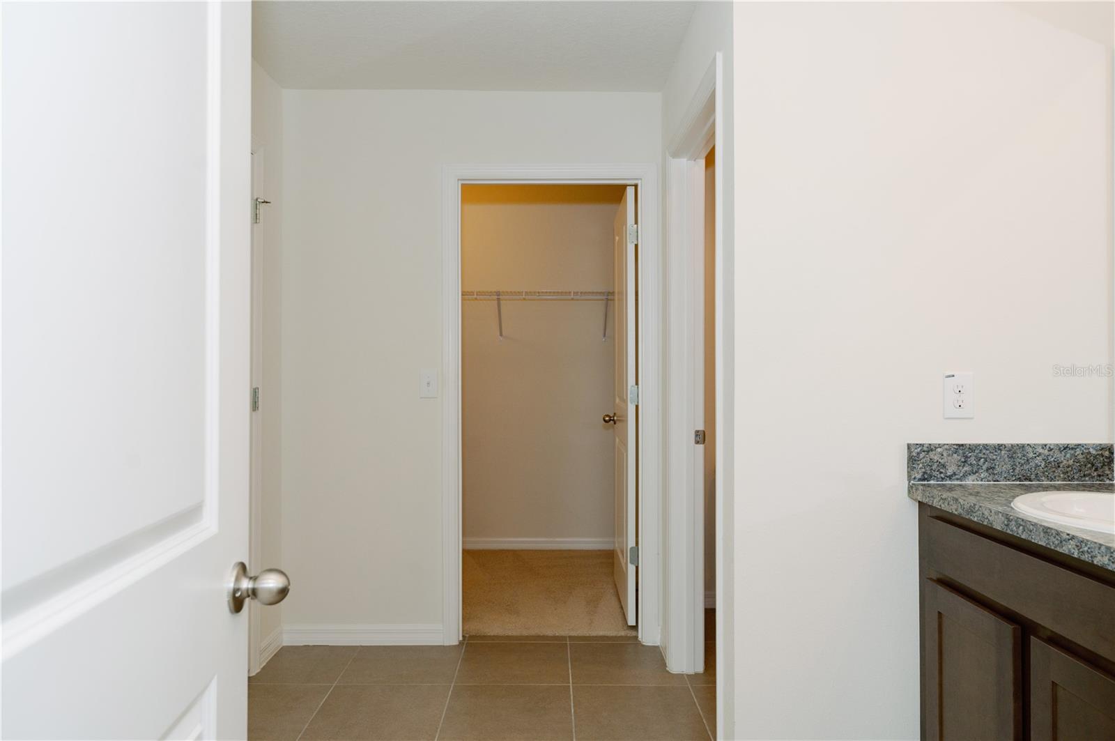 View from primary bathrrom door looking at walk-in closet door