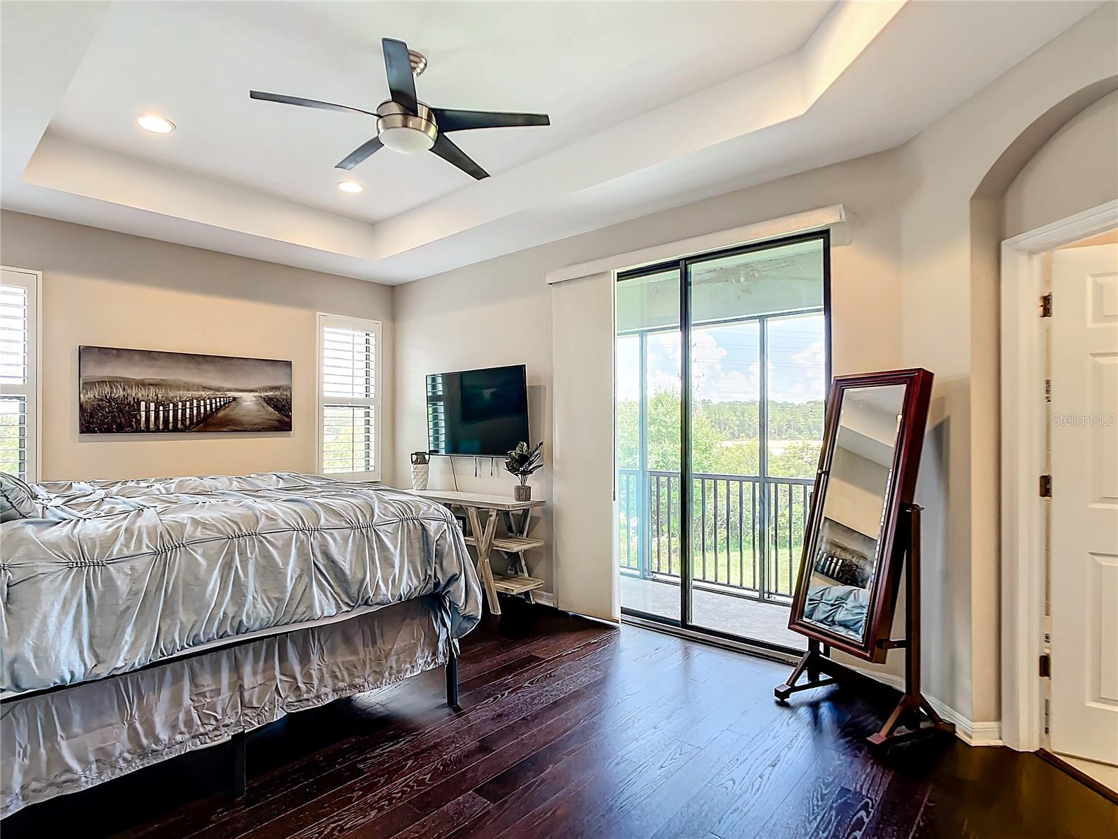 Master bedroom with balcony overlooking backyard