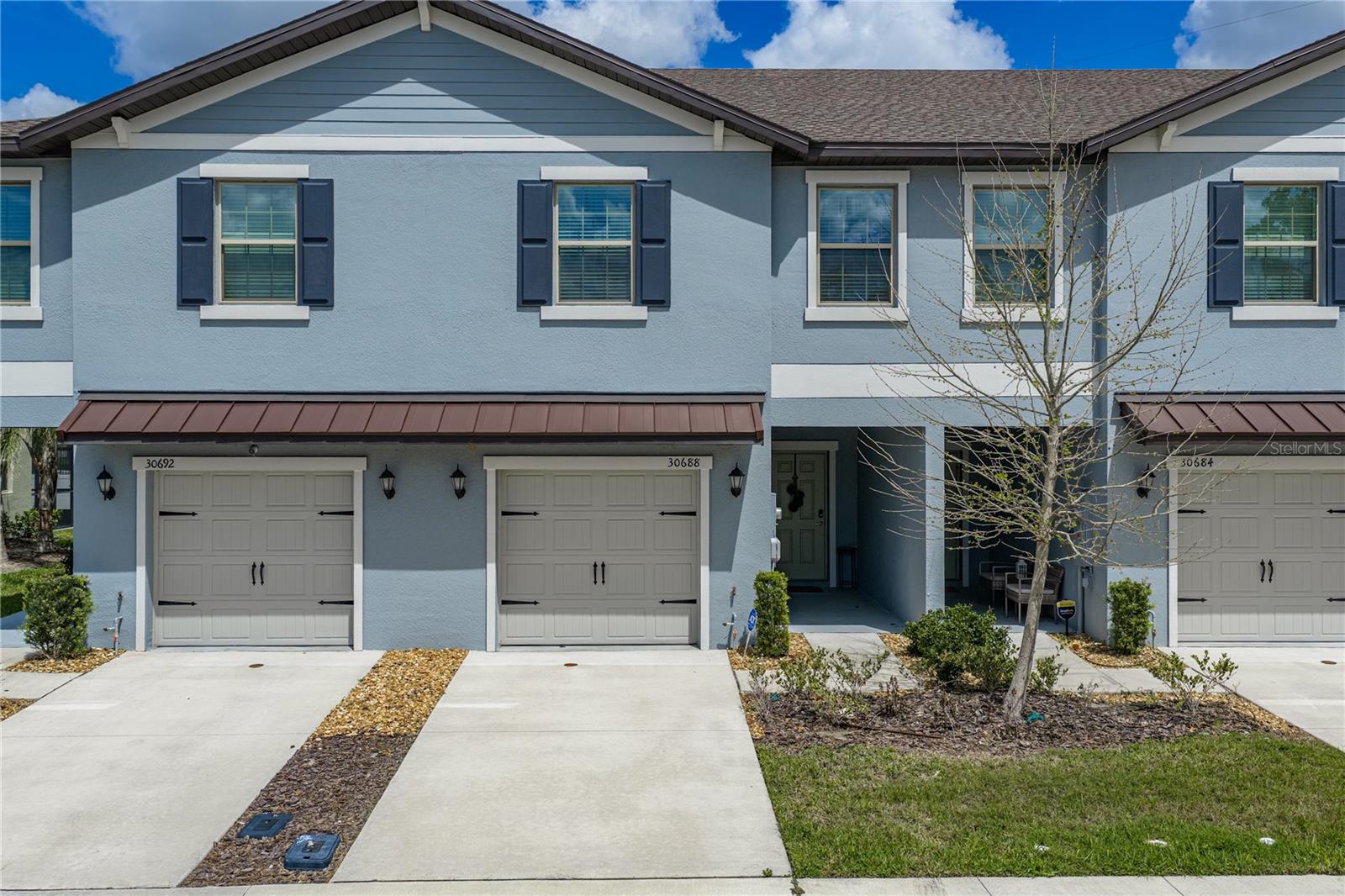 Front Exterior with Charming Metal Roof Accents and Garage Carraige Door Hardware