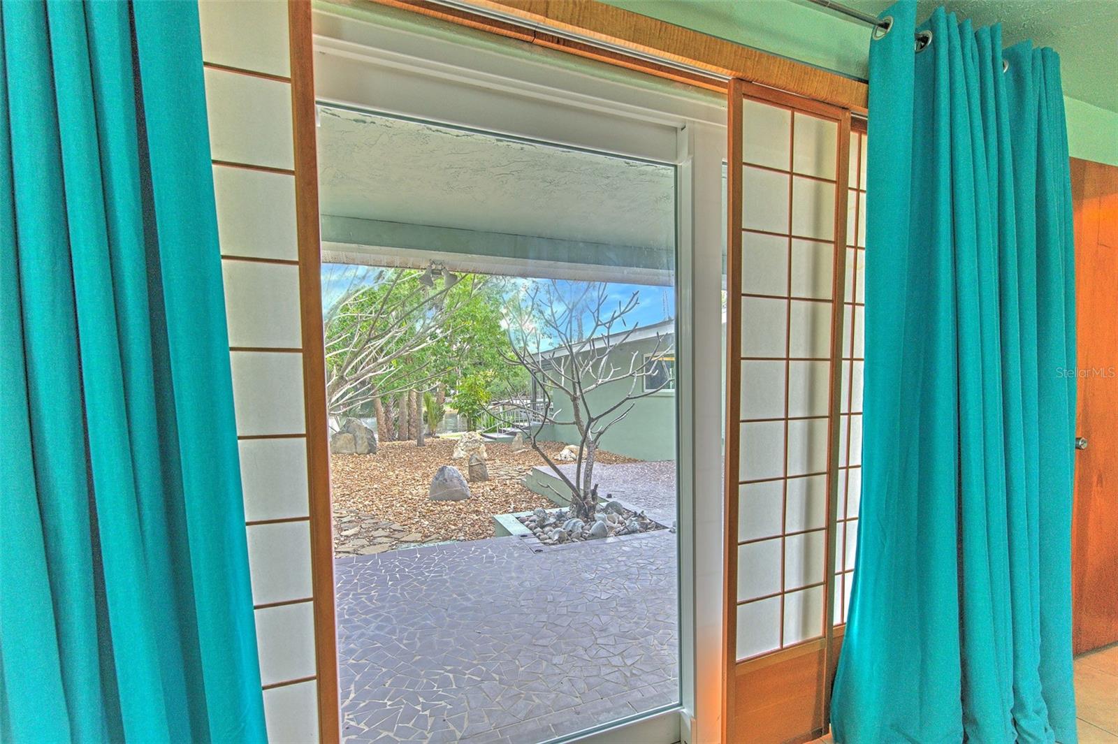 Master Bedroom 1 overlooking water and rock garden