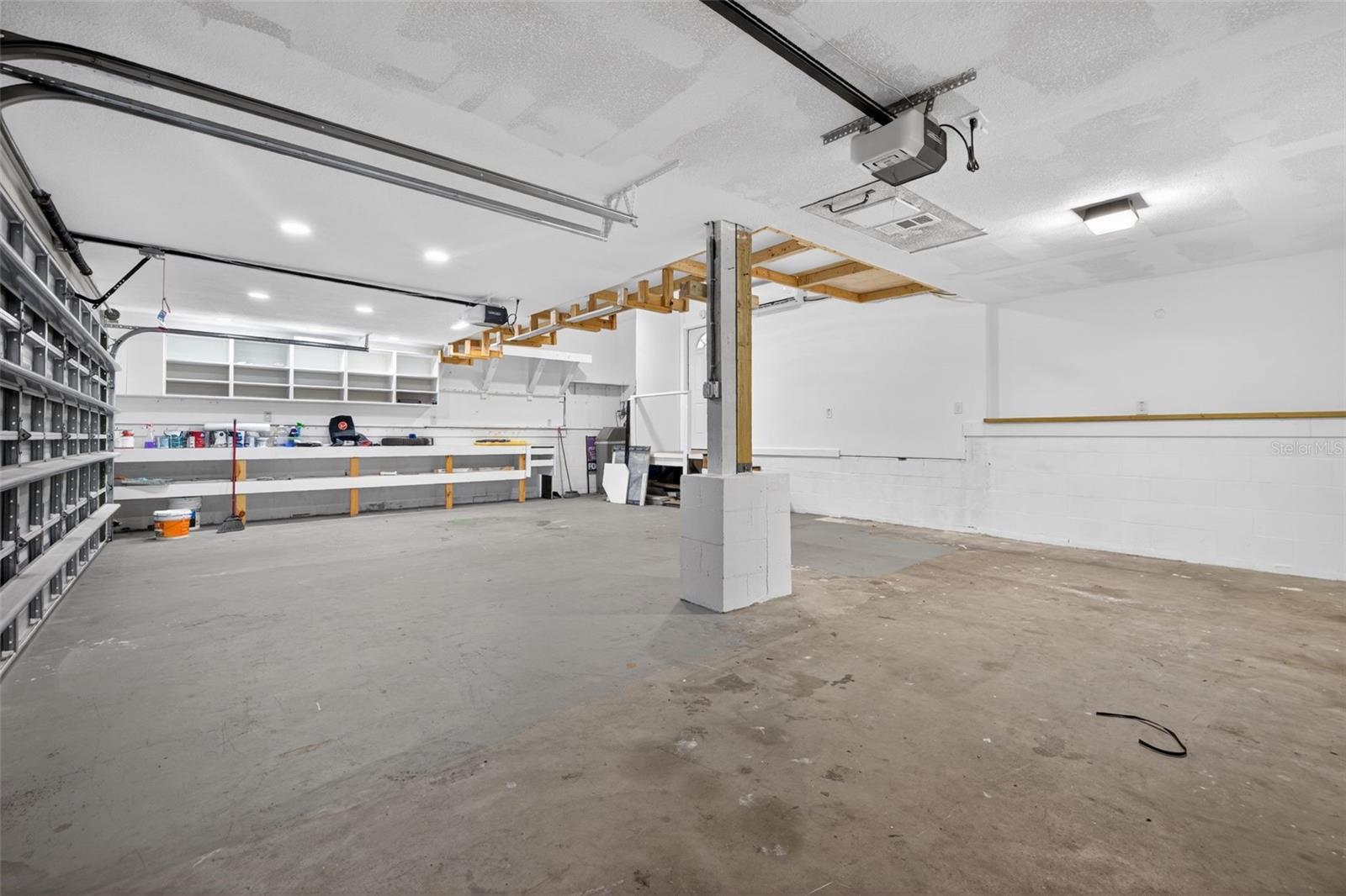 Another view of the 3 car garage, including a work bench and storage space.