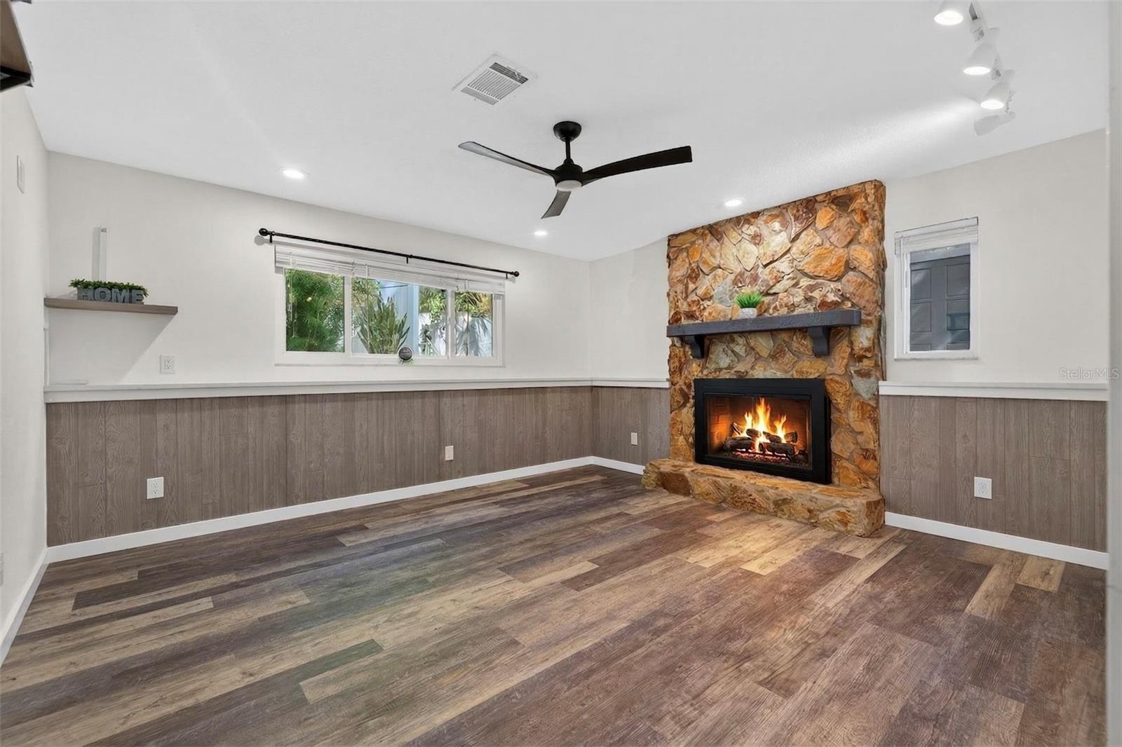 Bedroom #1 featuring wood burning fireplace, ceiling fan and recessed lighting. It has a small storage closet.