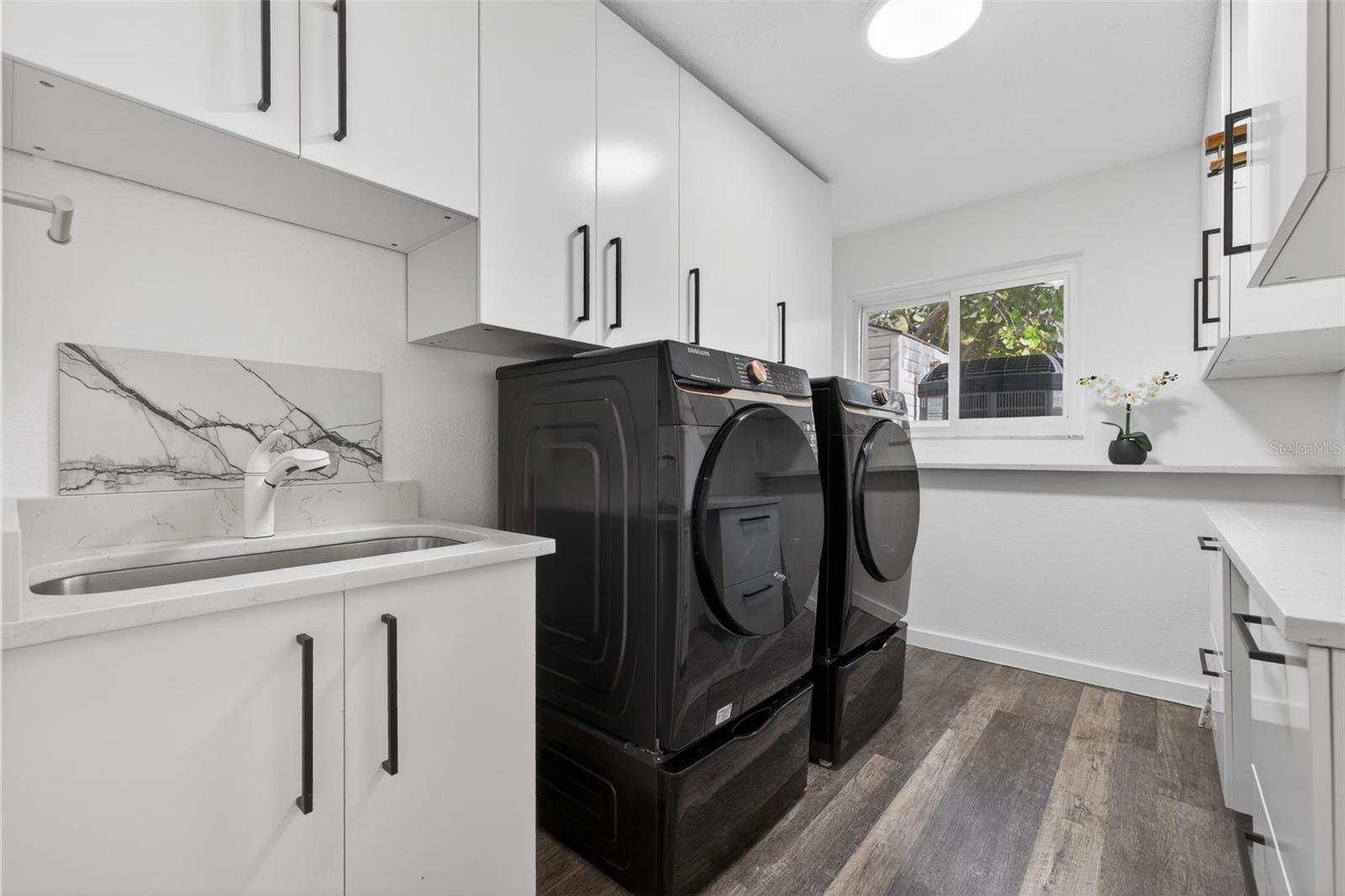 The home comes with a spacious laundry room featuring a utility sink, cabinetry, and workspace.Washer an dryer stays with the house.