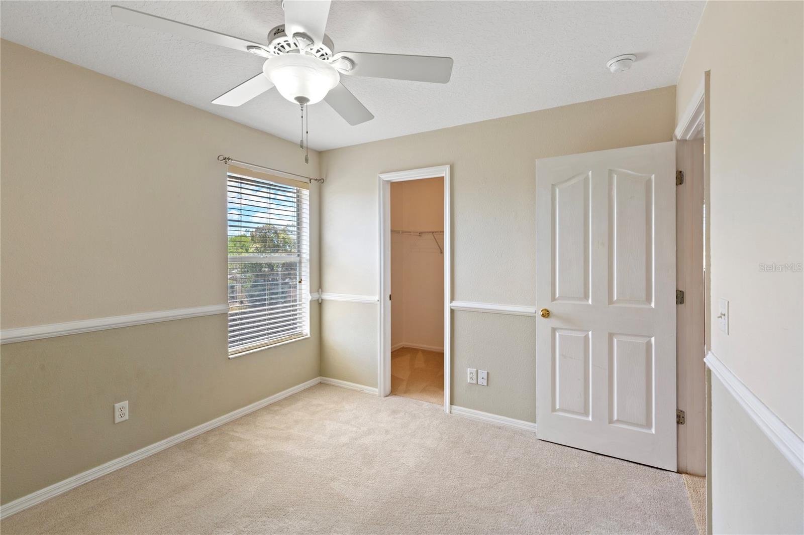 Walk in closet and ceiling fan.