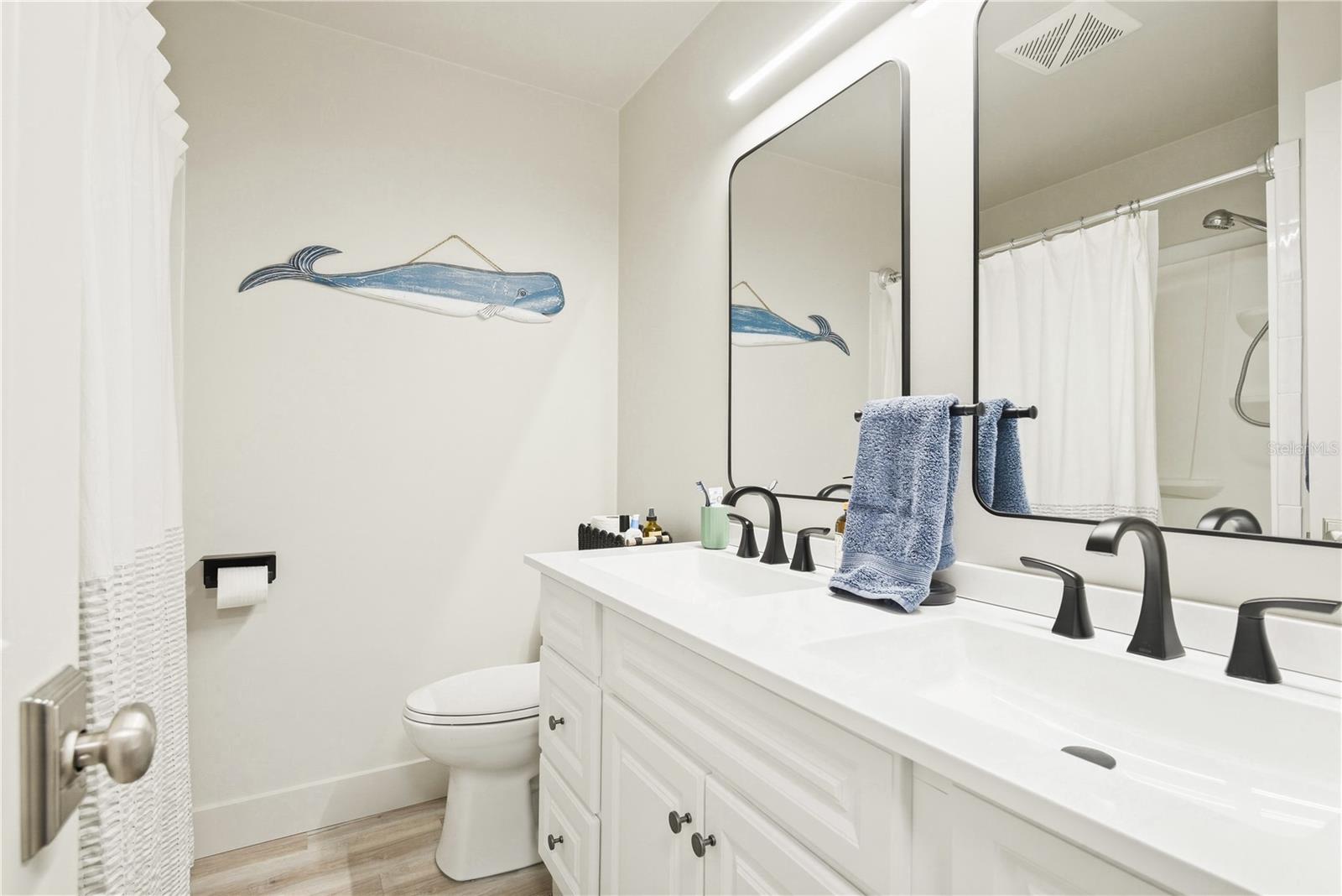 Full bathroom with tub shower and double vanity.