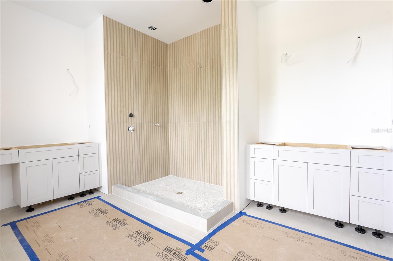 Primary en-suite bathroom with dual sinks, walk-in shower, soaking tub, and a morning/coffee station complete with a beverage cooler