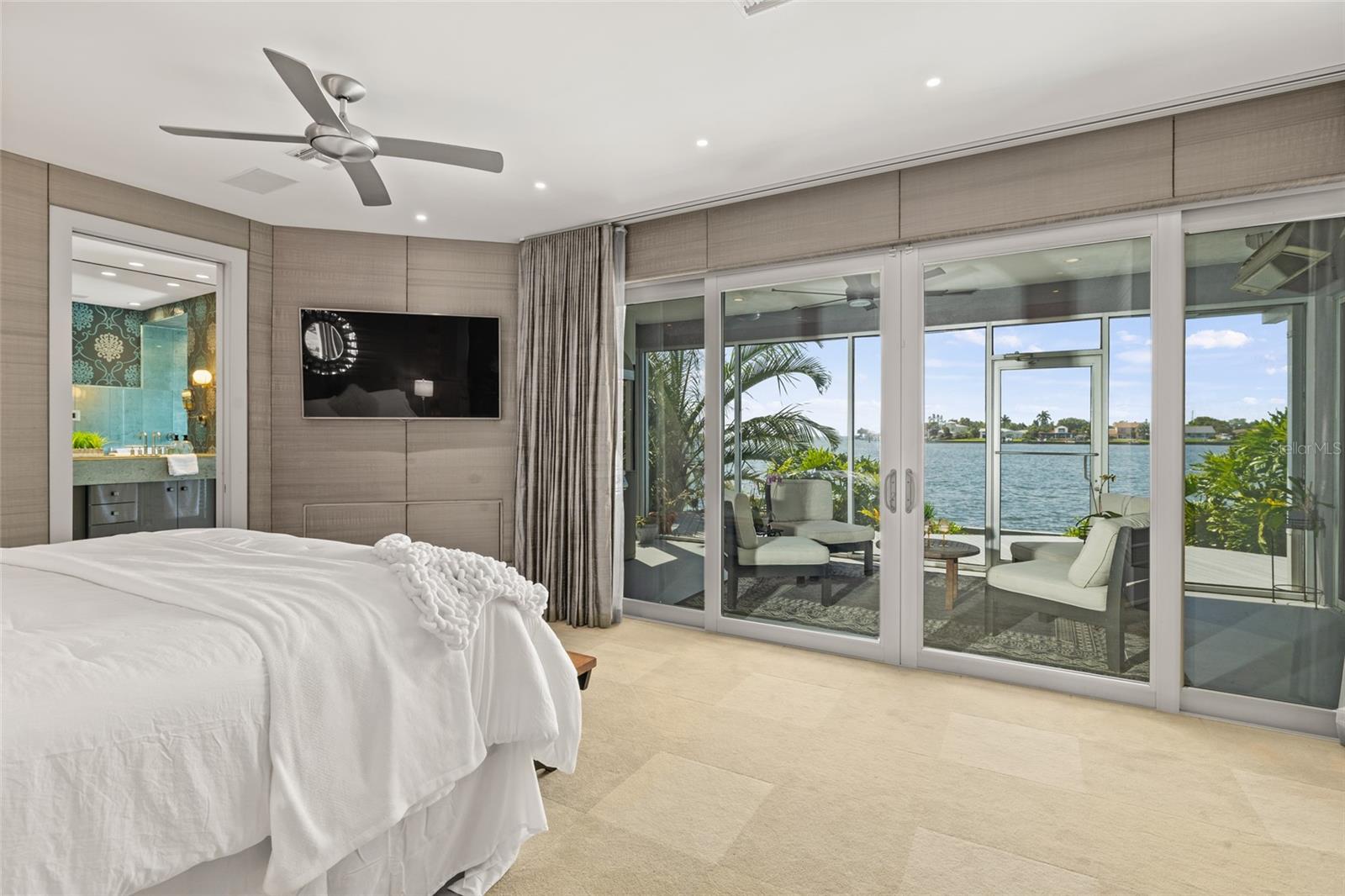 Waterfront primary bedroom with direct lanai access and tranquil bay views