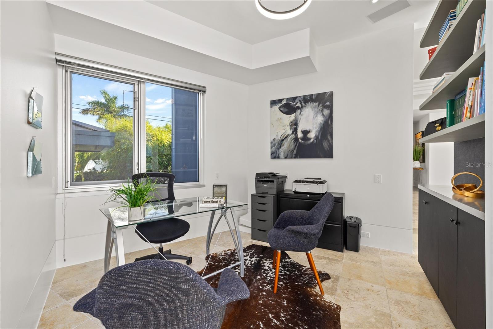 Home office with custom shelving and abundant natural light