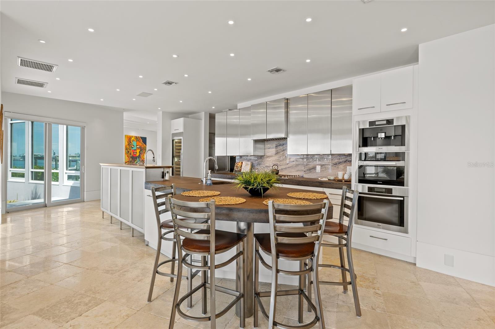 Spacious eat-in kitchen with oversized island, custom cabinetry, and luxury appliances by Miele & Fishery Paykel
