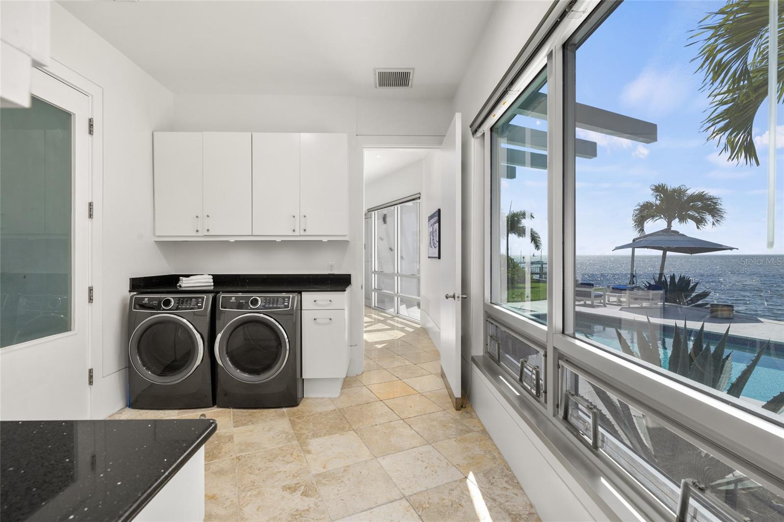 Bright laundry room with built-in storage and sweeping waterfront views
