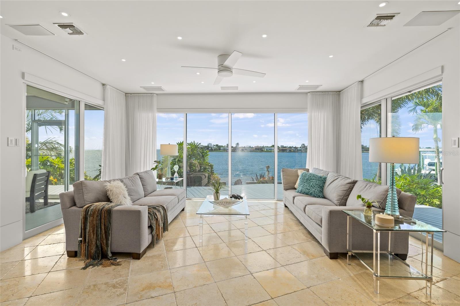 Bright waterfront family room with expansive glass, serene views, and modern comfort
