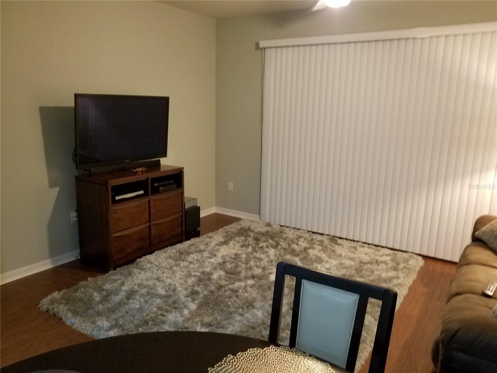 Spacious living room with a clean, open layout and direct access to the backyard—perfect for relaxing, entertaining, and enjoying seamless indoor-outdoor living.