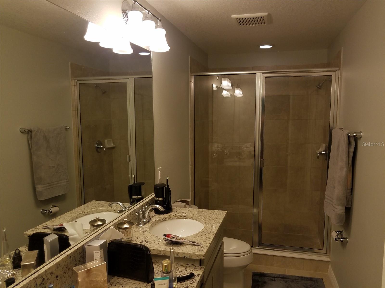 Relax in your private primary bath with granite vanity, elegant finishes, and a large glass-enclosed shower—creating a clean, spa-like retreat.