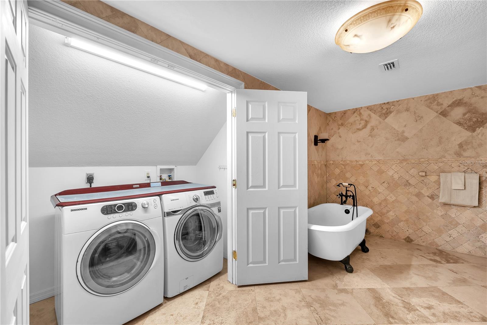 Washer & Dryer in the primary ensuite tucked behind double closet doors.  There is an additional washer & dryer in the garage downstairs for added convenience.