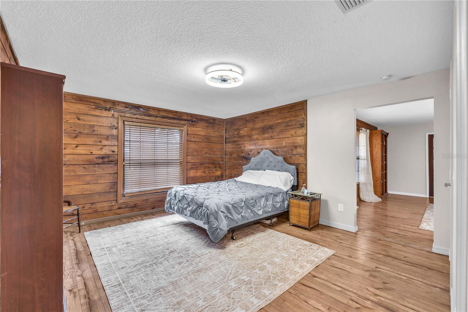 Flexible first-floor bedroom with exposed cedar log accents has access to a Full bathroom ensuite with step-in shower and an enormous walk-in closet and storage area.
