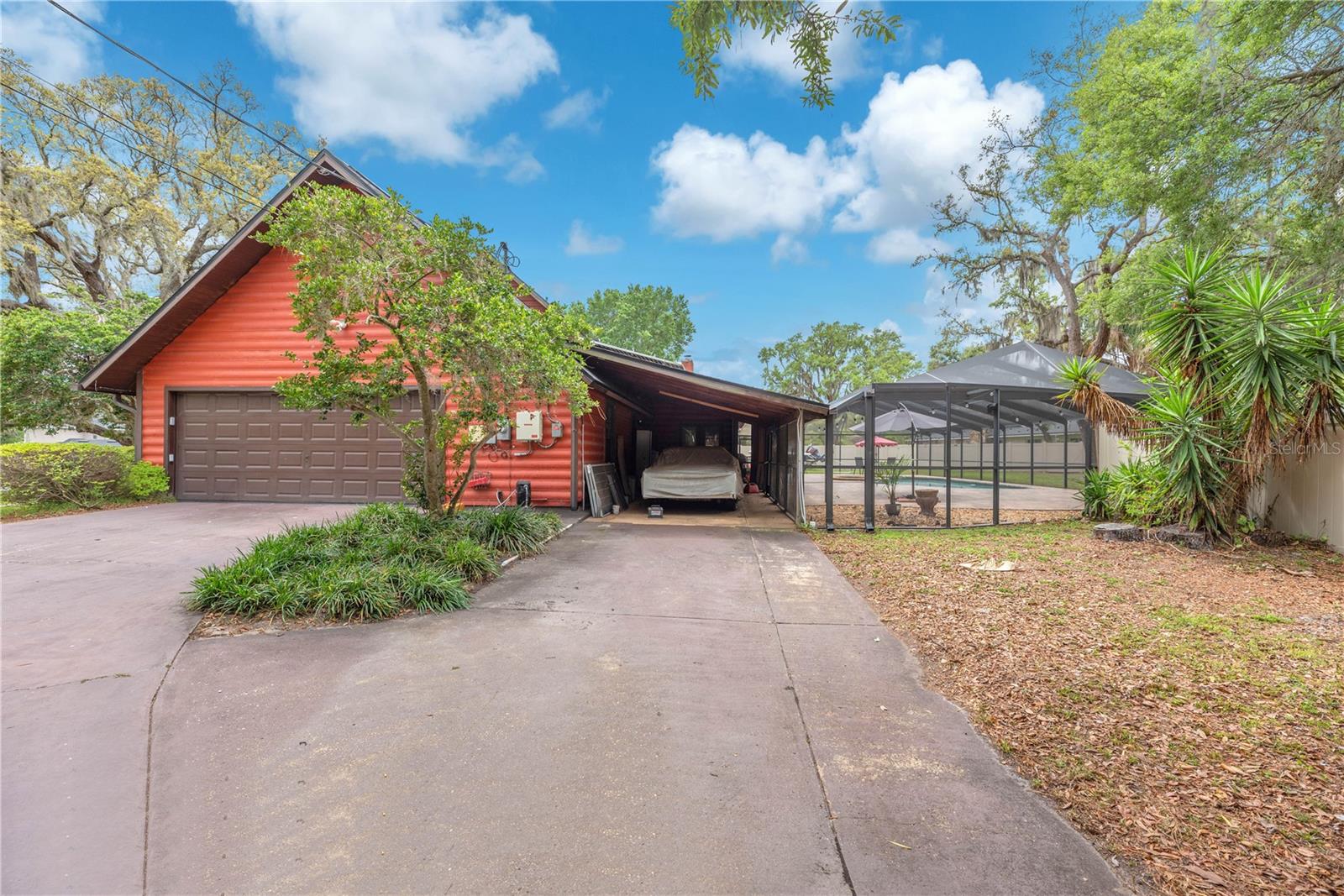 An attached single carport, a two-car side-entry garage, and an extended driveway provide ample room for multiple vehicles, boats, or RVs.