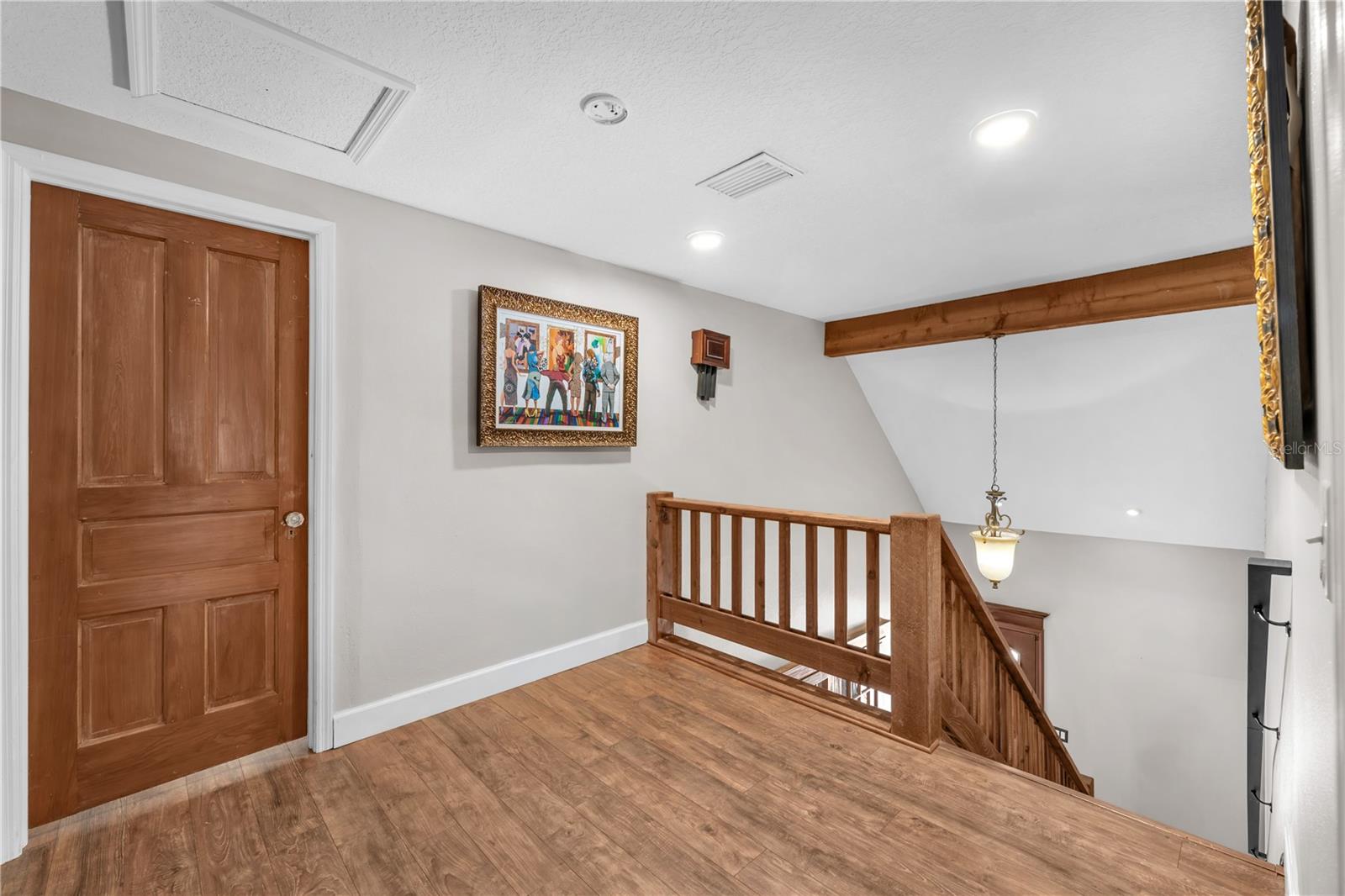 Upstairs is the Primary suite and an additional bedroom with ensuite and walk-in closet.  Notice the antique doors with glass knobs and wood beam details.