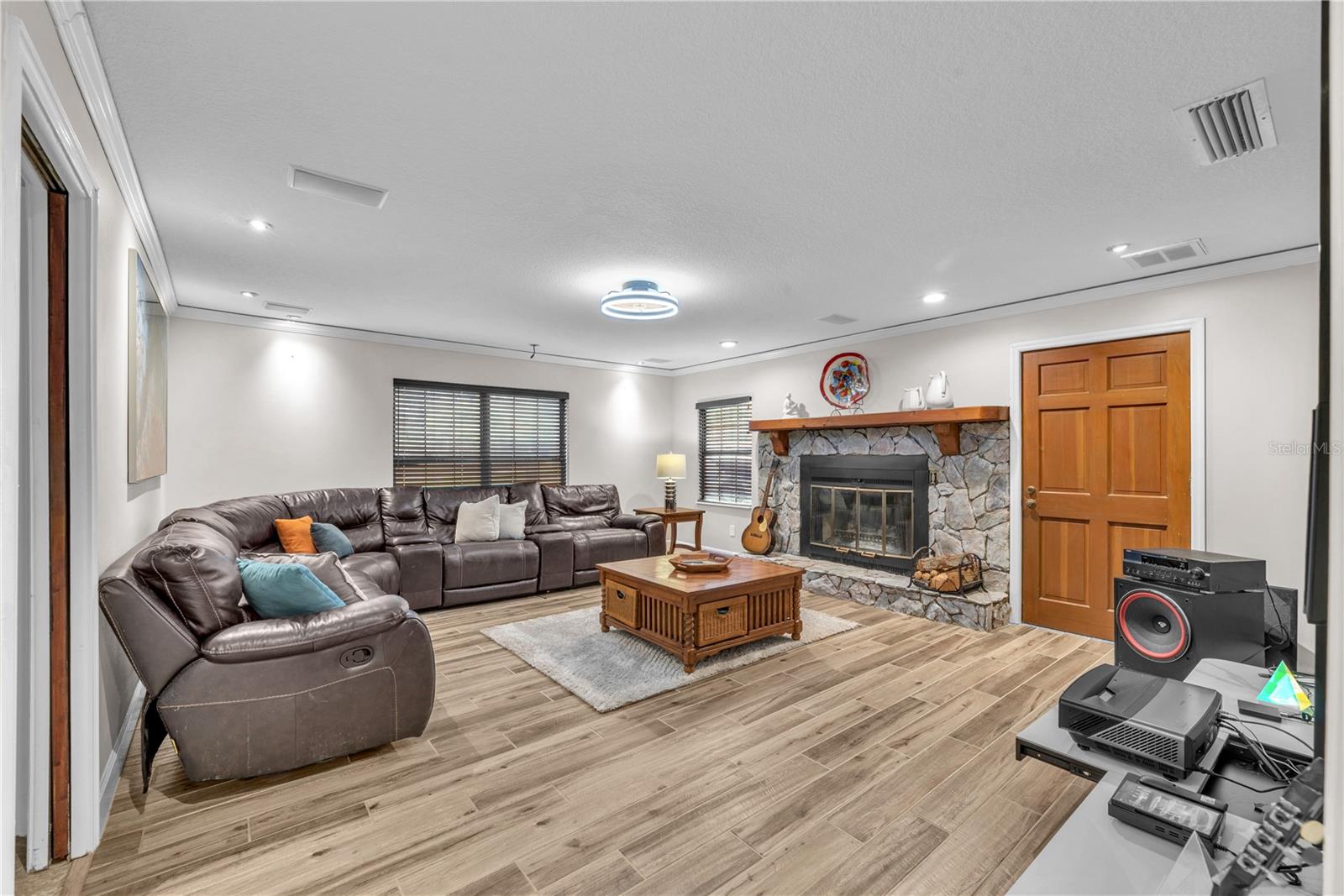 This room is anchored with a dramatic wood-burning stone fireplace