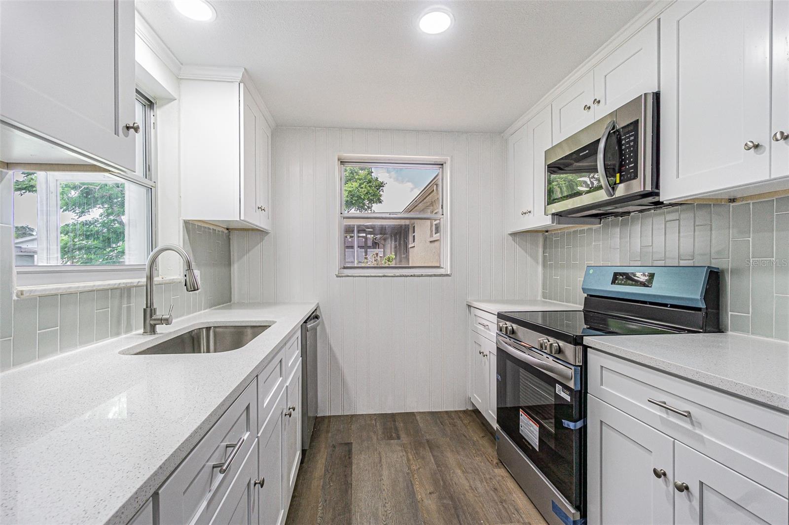 All new kitchen! Soft touch drawers, Quartz countertops, vertical, sage green subway tile, accent wall and stainless steel appliance.