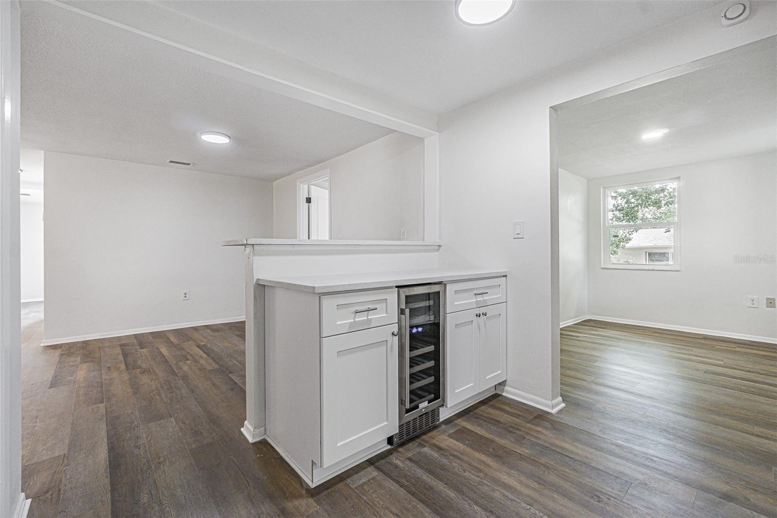 Breakfast bar with wine cellar and view to den and dining area