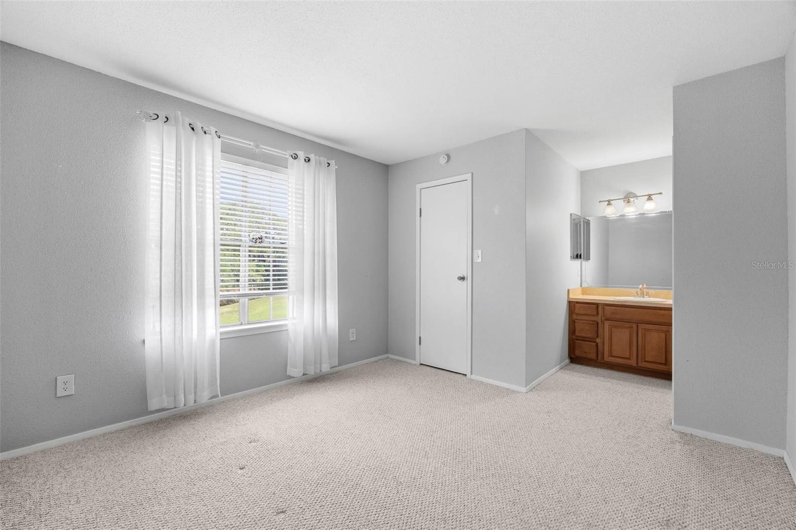Primary Bedroom with window overlooking park-like setting
