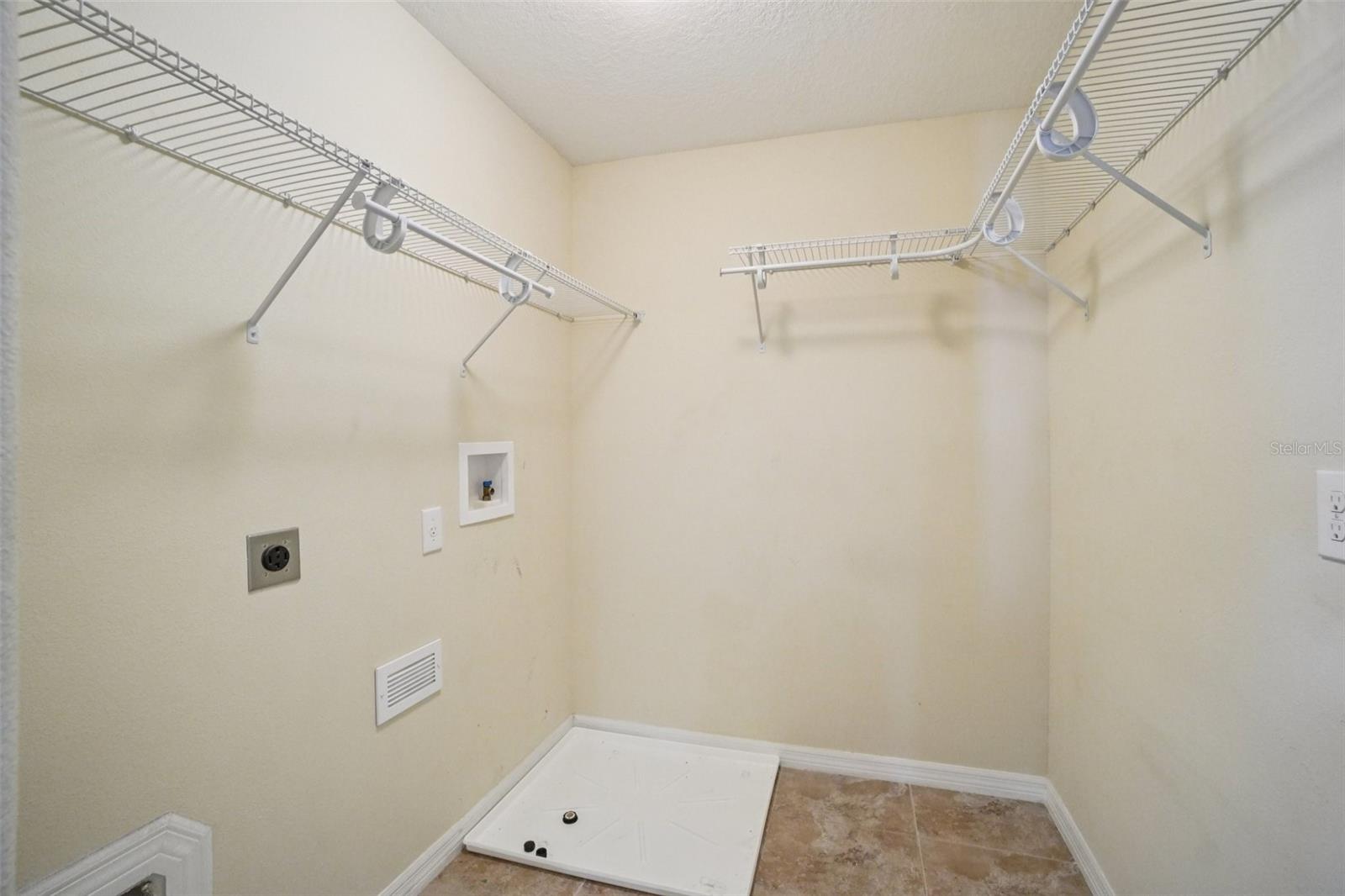 Laundry RoomThe conveniently located upstairs laundry room features tile flooring, wire shelving, electric dryer outlet, washer hook-ups, and a built-in pet door — a practical and well-equipped space just steps from the bedrooms.